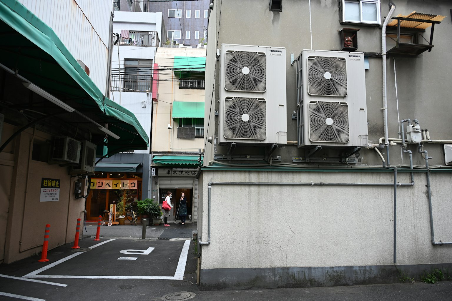Esterno di un edificio con unità di climatizzazione e una scena di strada stretta
