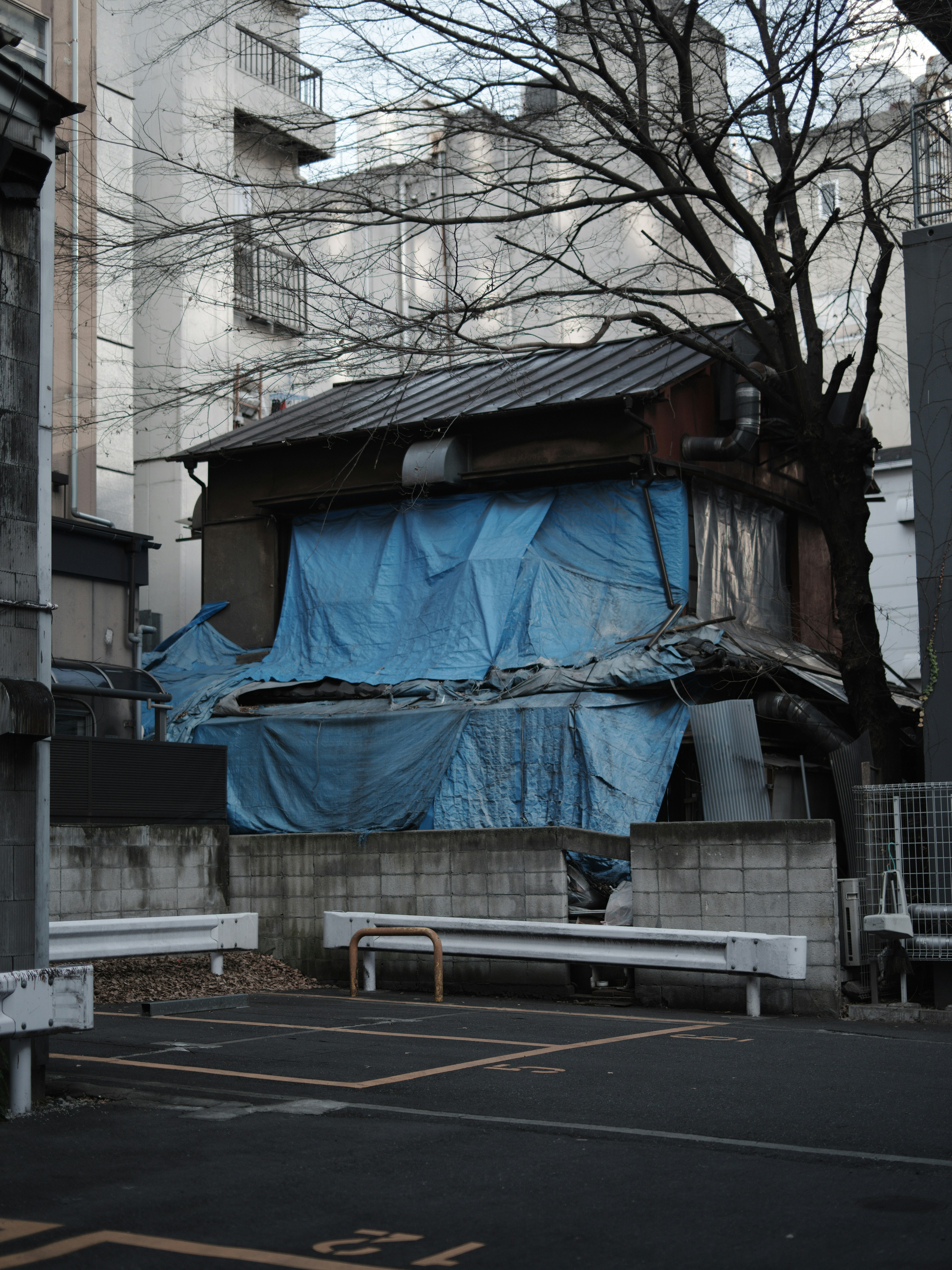 ブルーシートで覆われた建物のある路地の風景