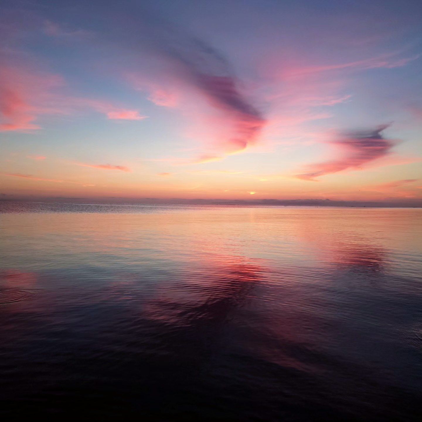 夕焼けの海面に広がる水平線の風景