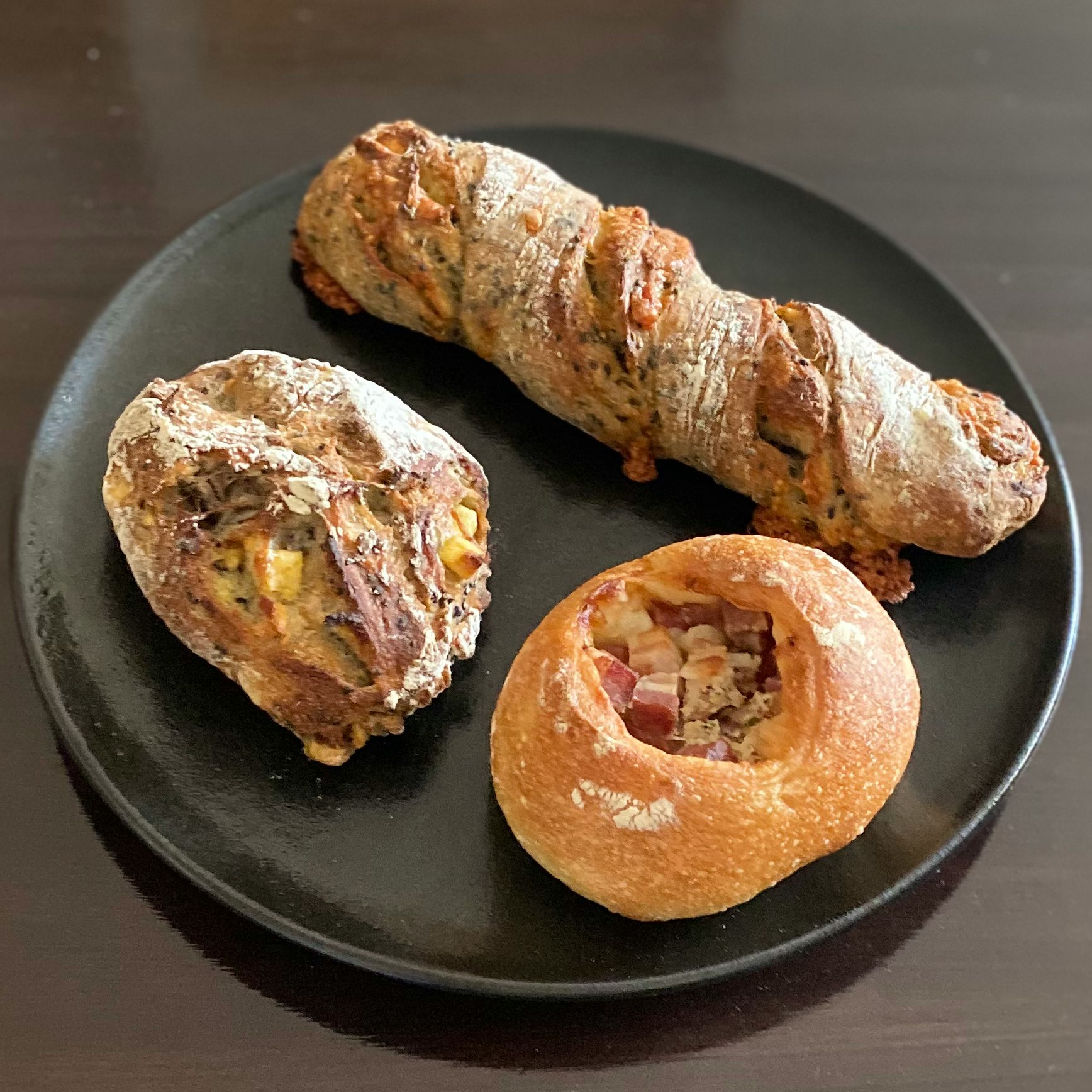 黑色盤子裡的麵包與夾餡貝果風