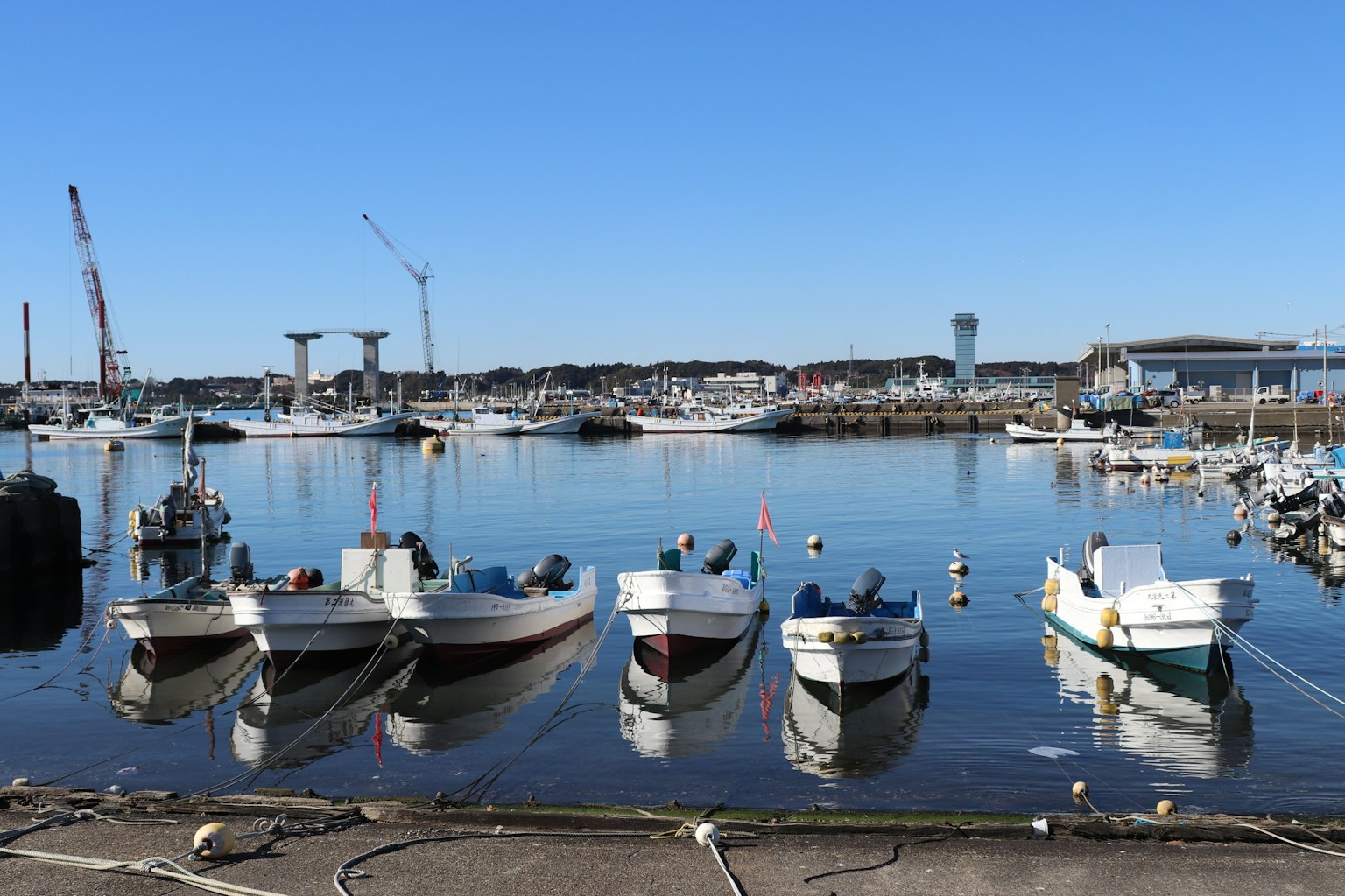 Pequeños barcos atracados en un puerto tranquilo con cielo azul claro