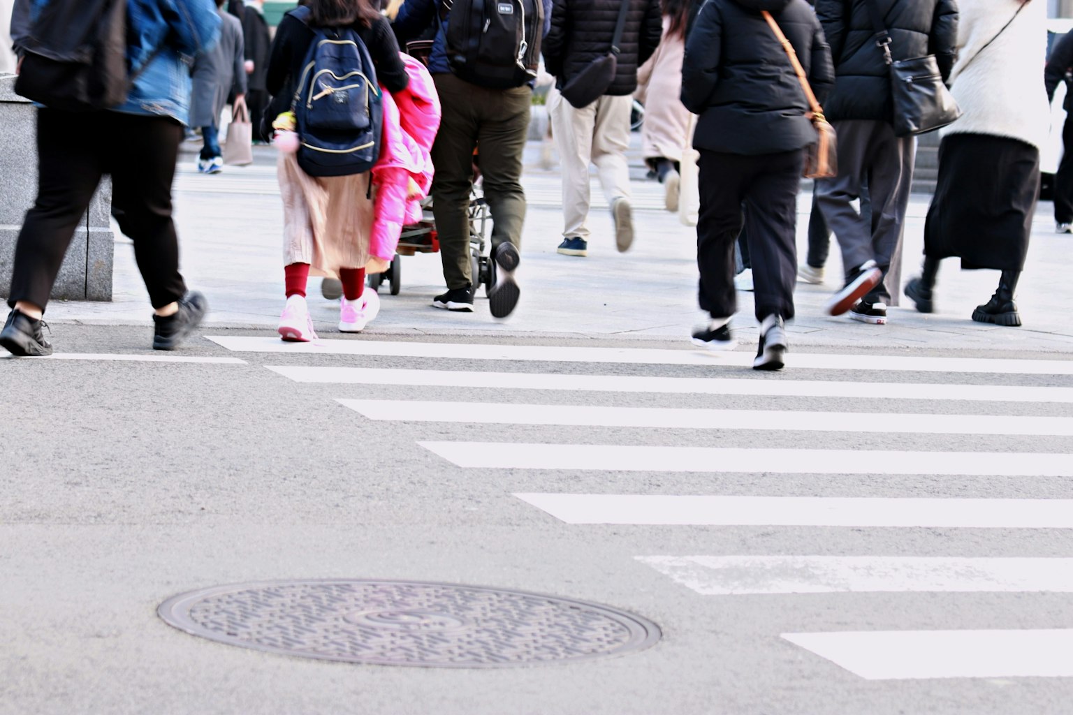 Une foule de personnes traversant une rue avec des vêtements colorés visibles