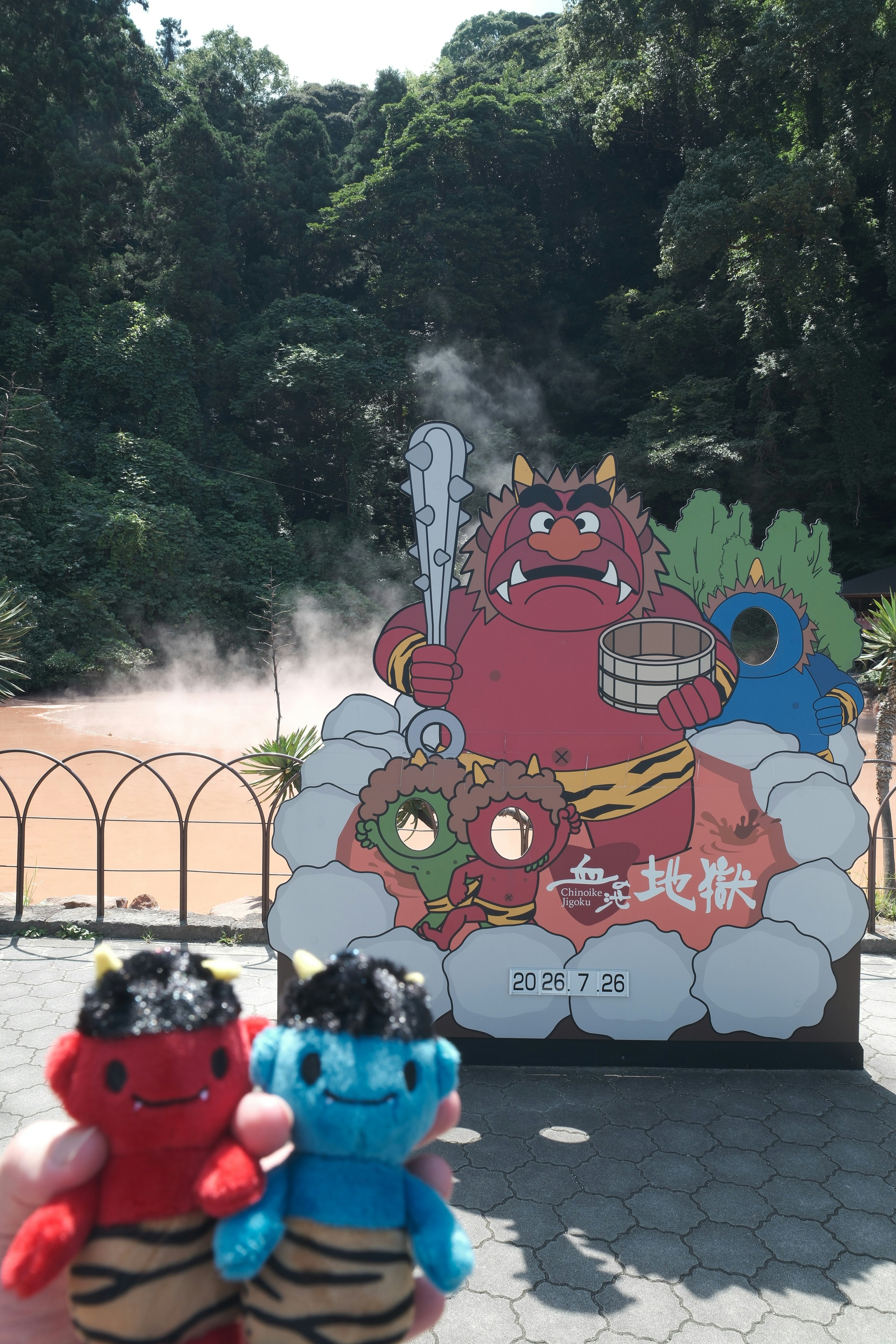 別府地獄巡りのキャラクター看板と湯けむりの風景