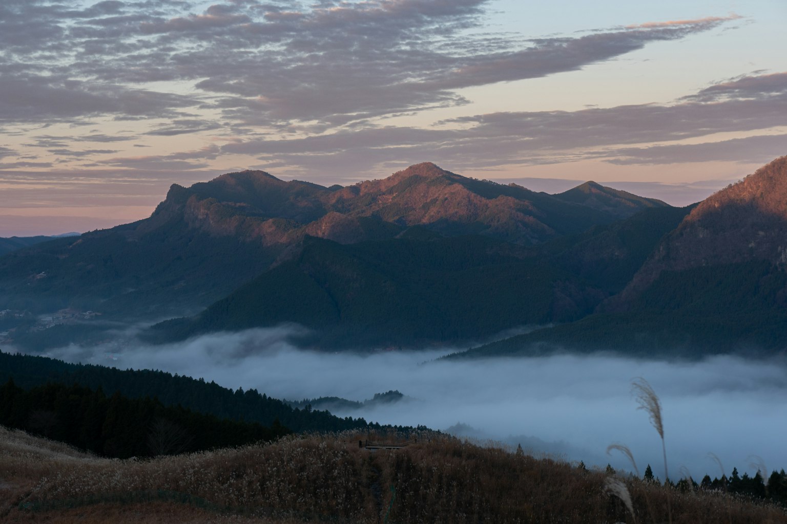 Vista panoramica di montagne nebbiose con cielo colorato all'alba