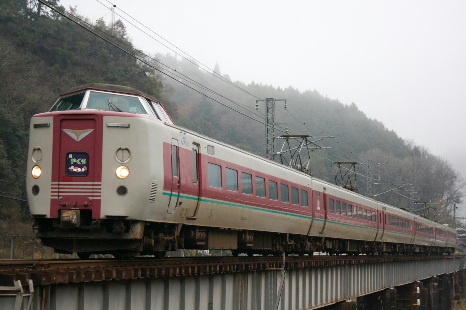 在霧中穿越高架橋的紅白列車