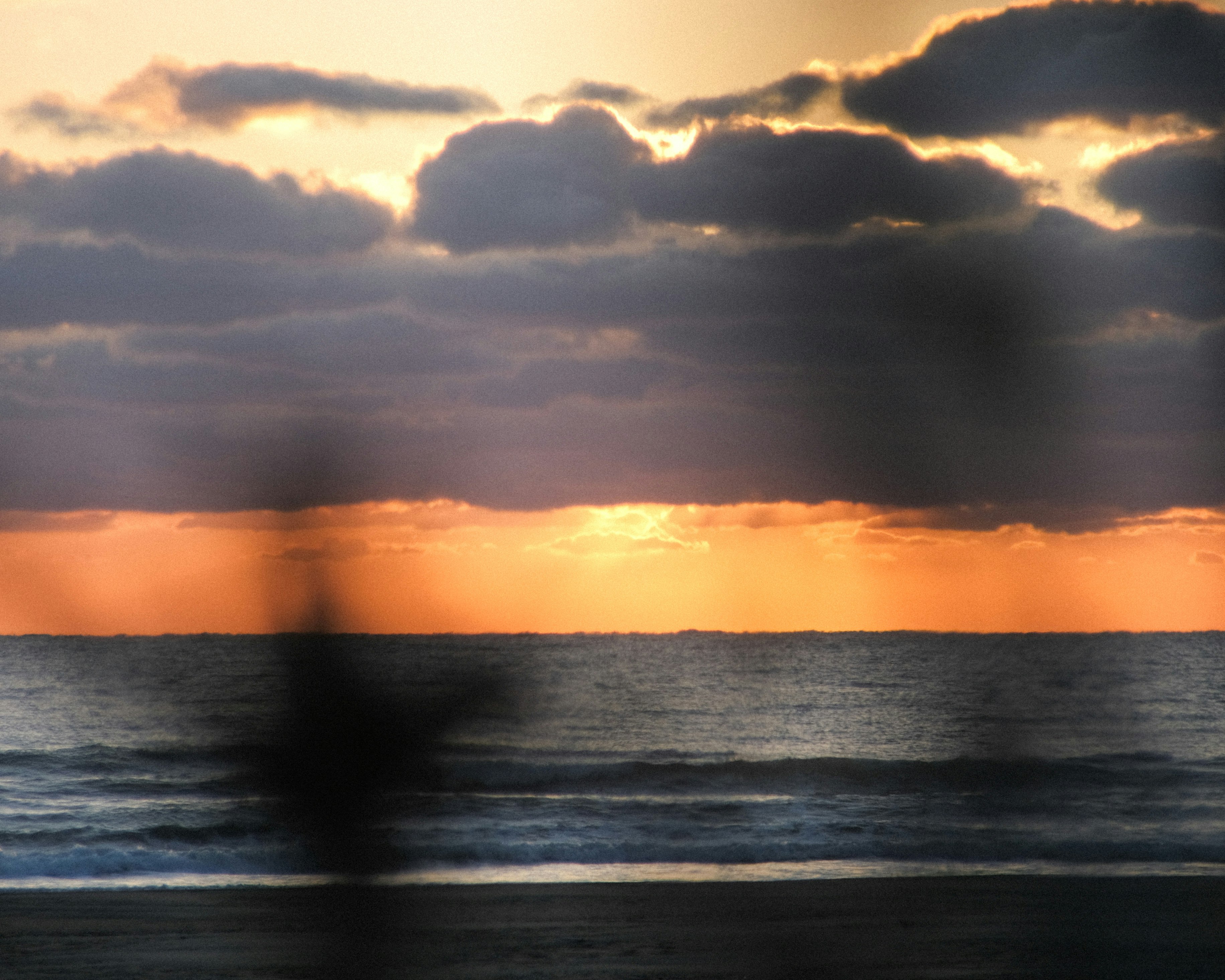 夕焼けの海と水平線に広がる雲の風景