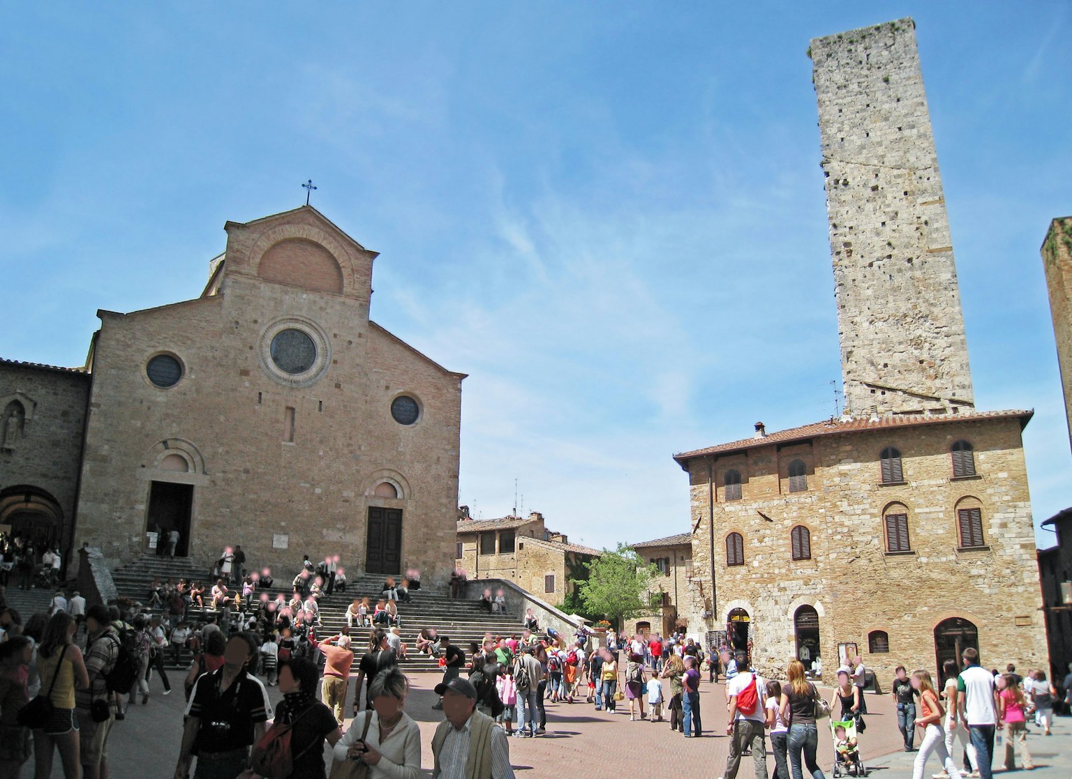 Historic church and tower in a bustling square filled with people