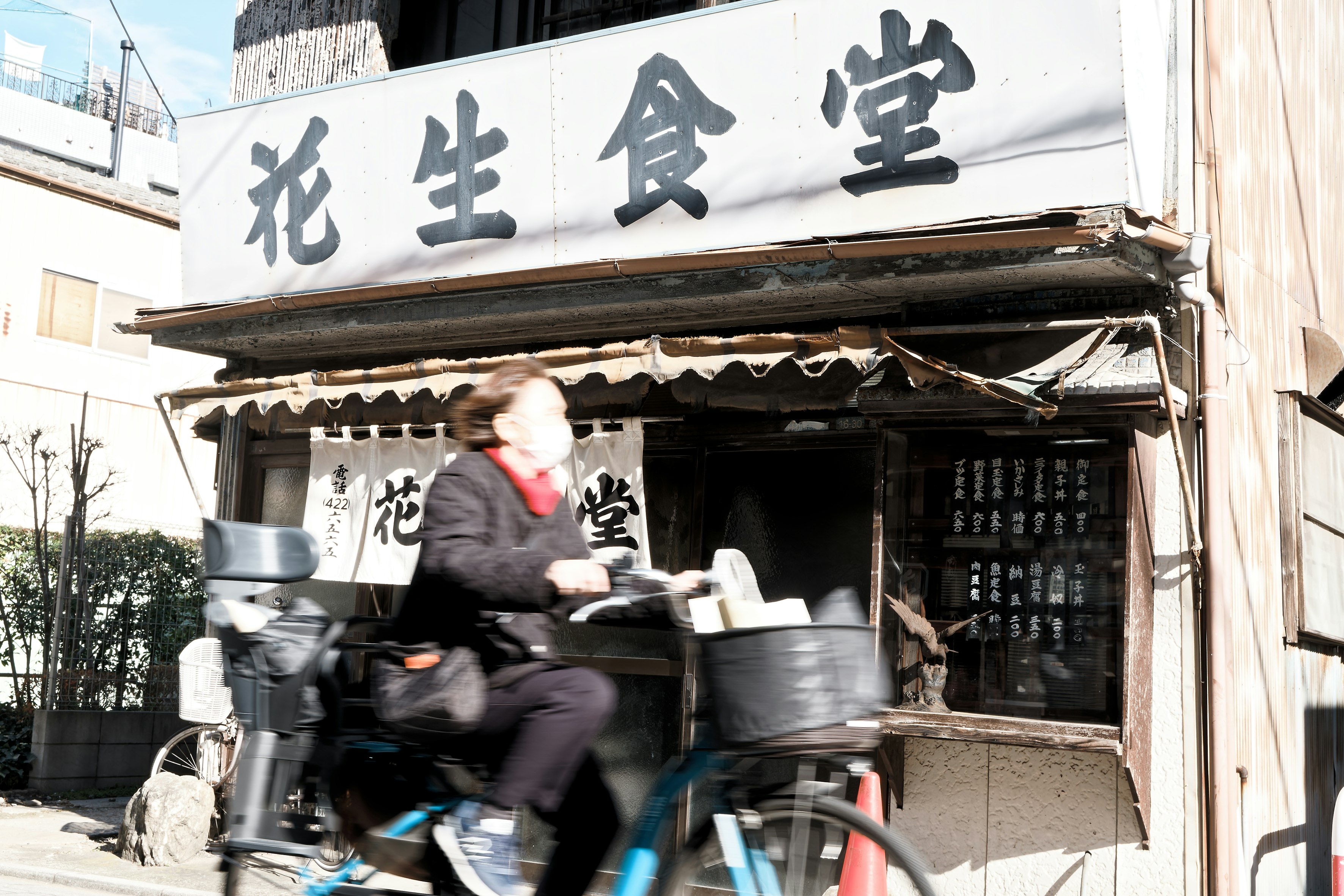 bicycles and cooking pots in front of a Chinese restaurant sign