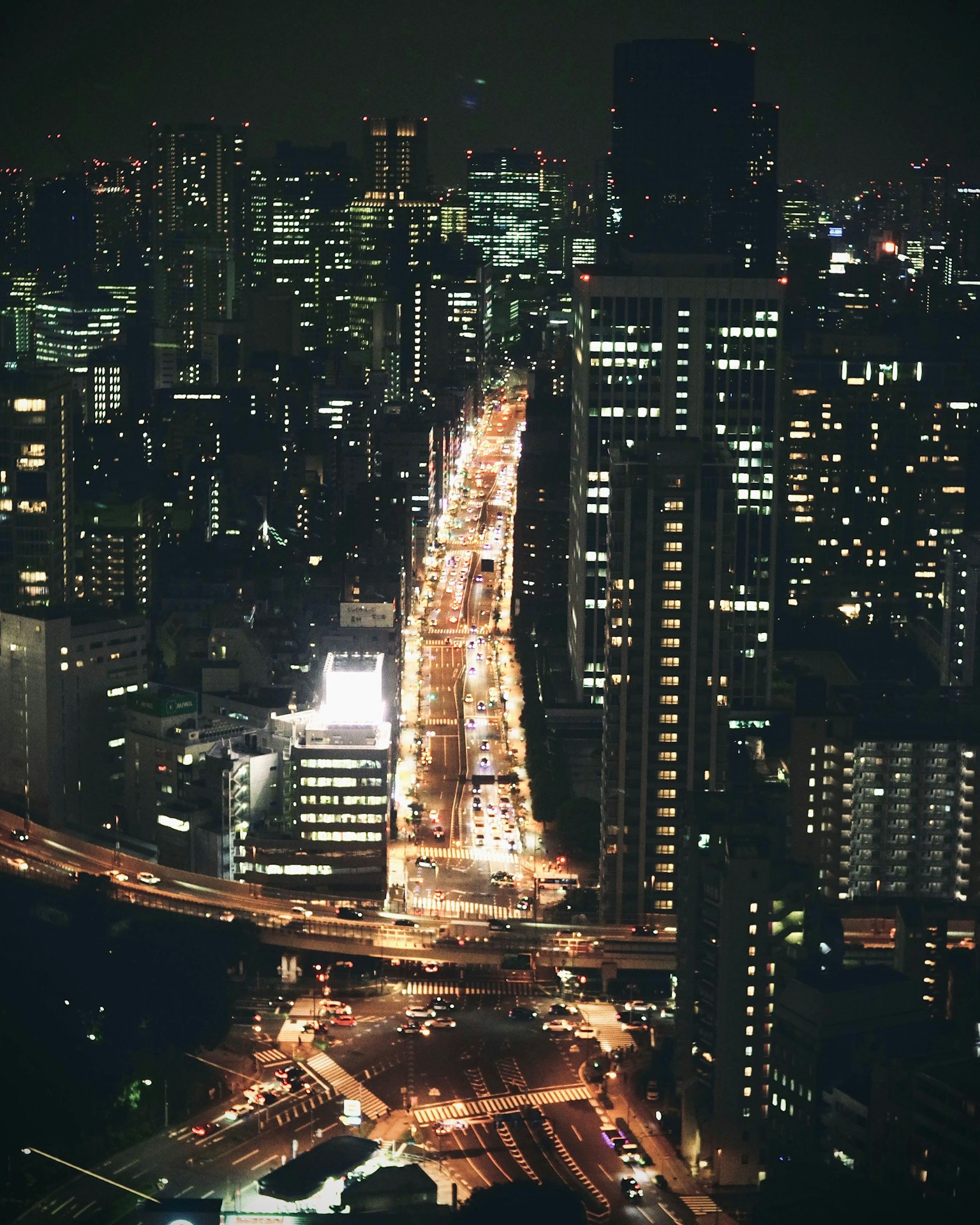 도쿄의 고층 빌딩과 조명이 있는 도로 교차로의 야경