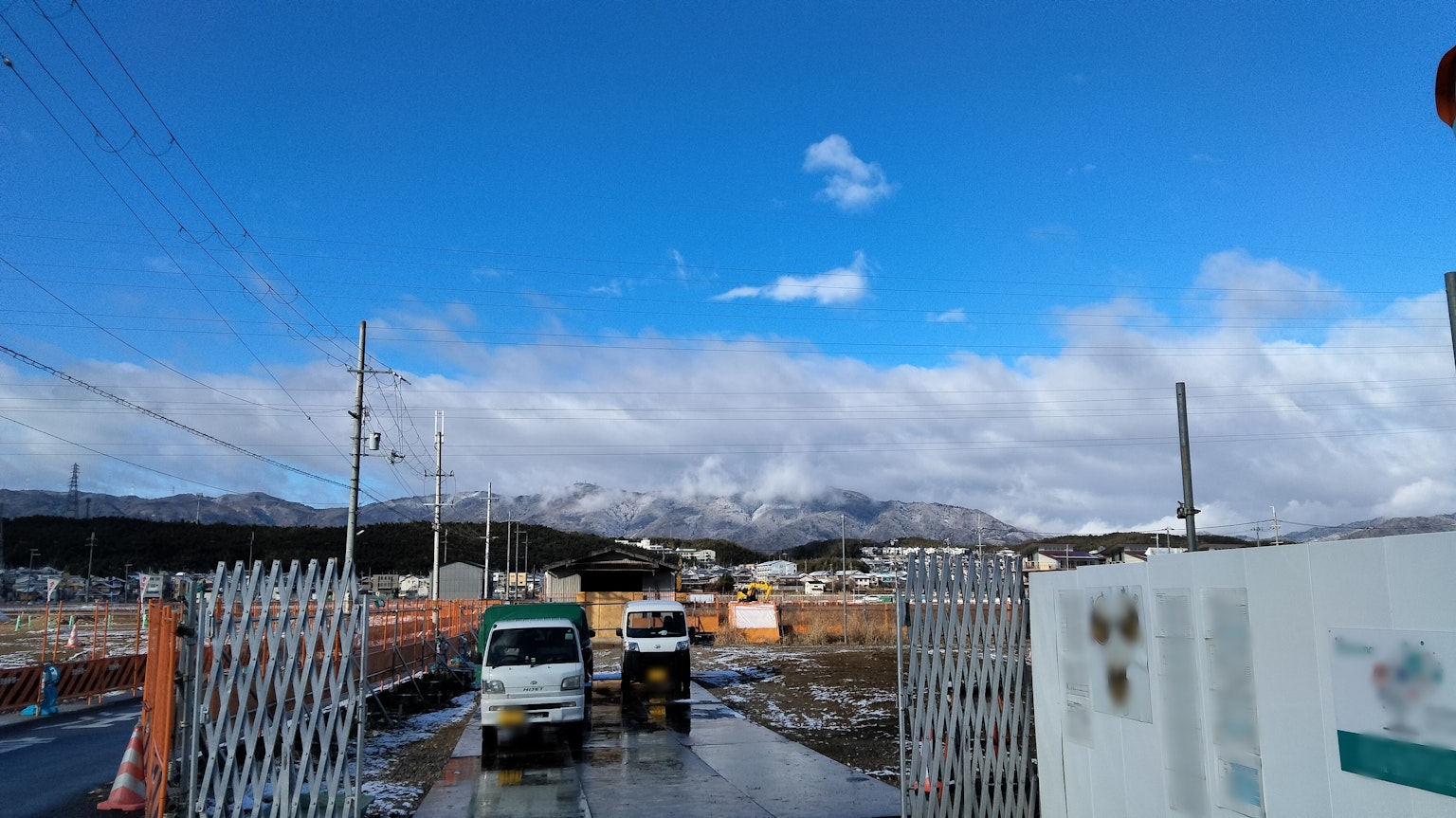 建筑工地入口，背景有清澈的蓝天和山脉