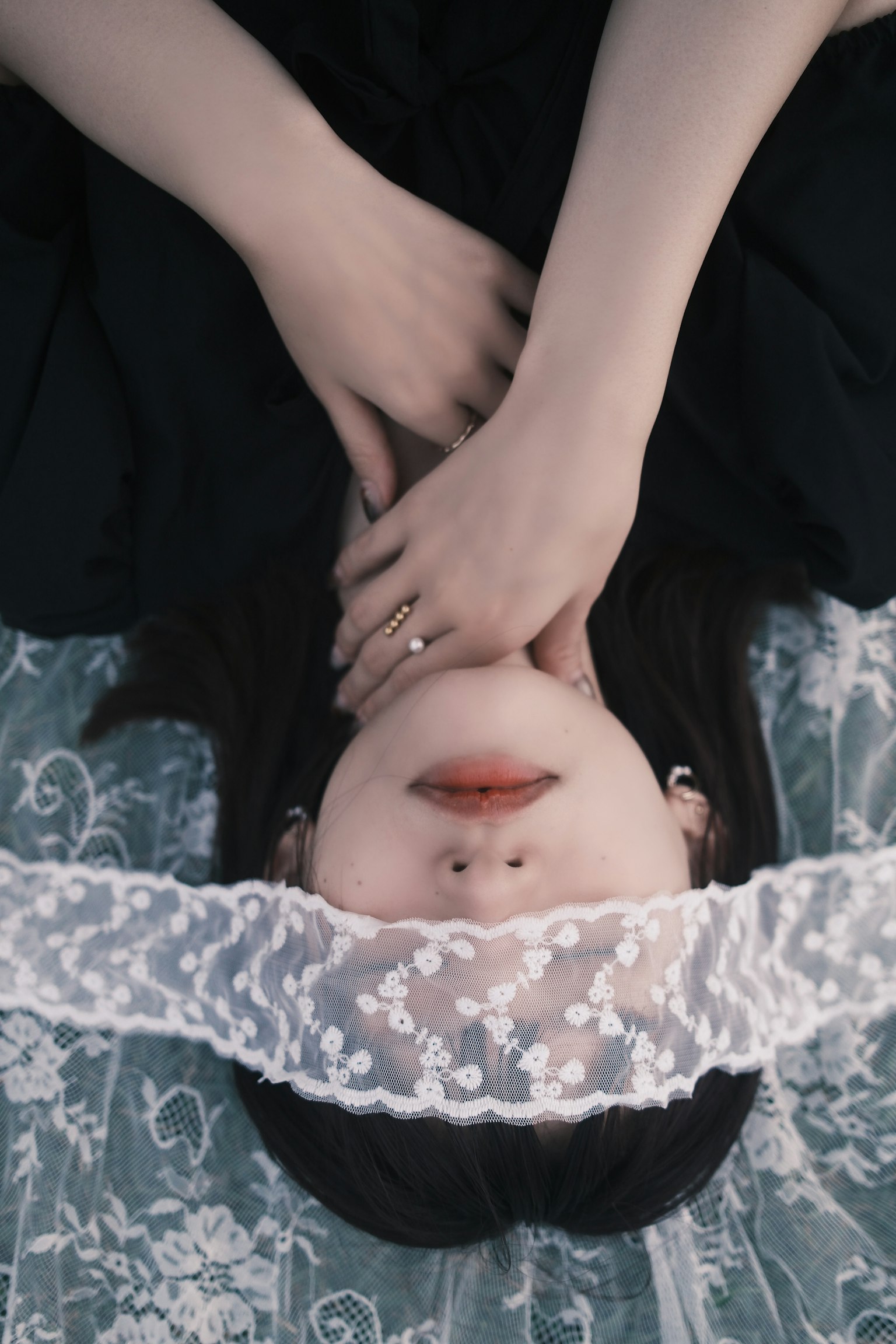 黒いドレスを着た女性がレースのベールで目を覆っている