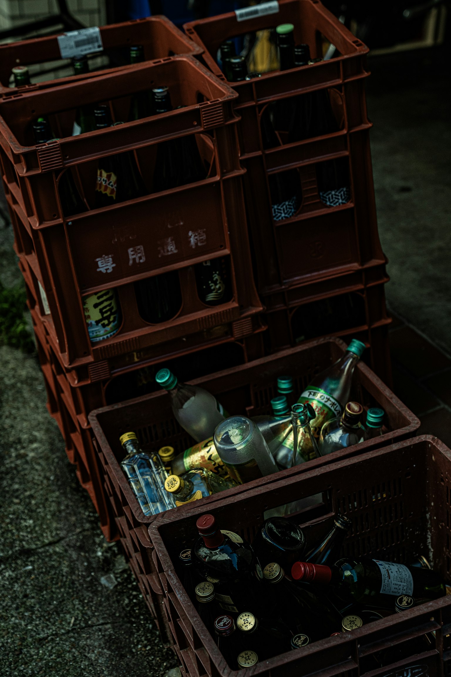 赤いプラスチックの箱に入った空の瓶と缶が並んでいる