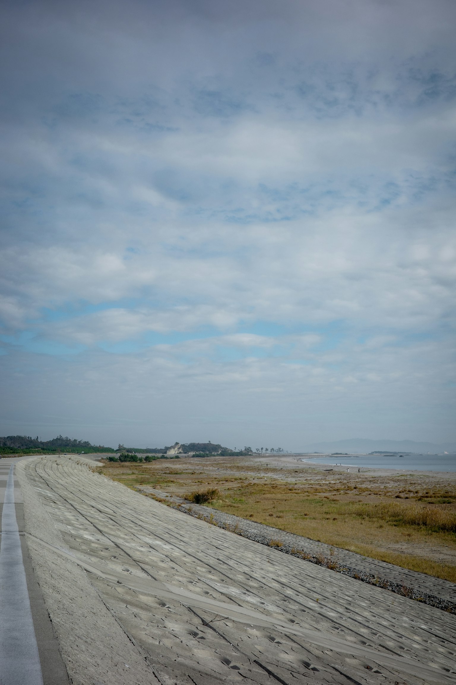 Tranquil coastline with a blue sky and sandy path