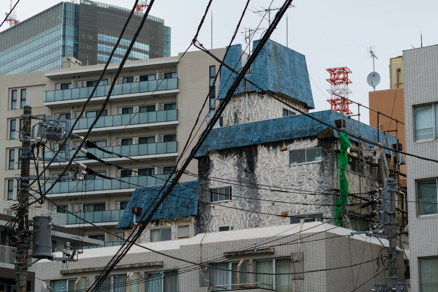 Un edificio antiguo con un techo azul junto a edificios modernos
