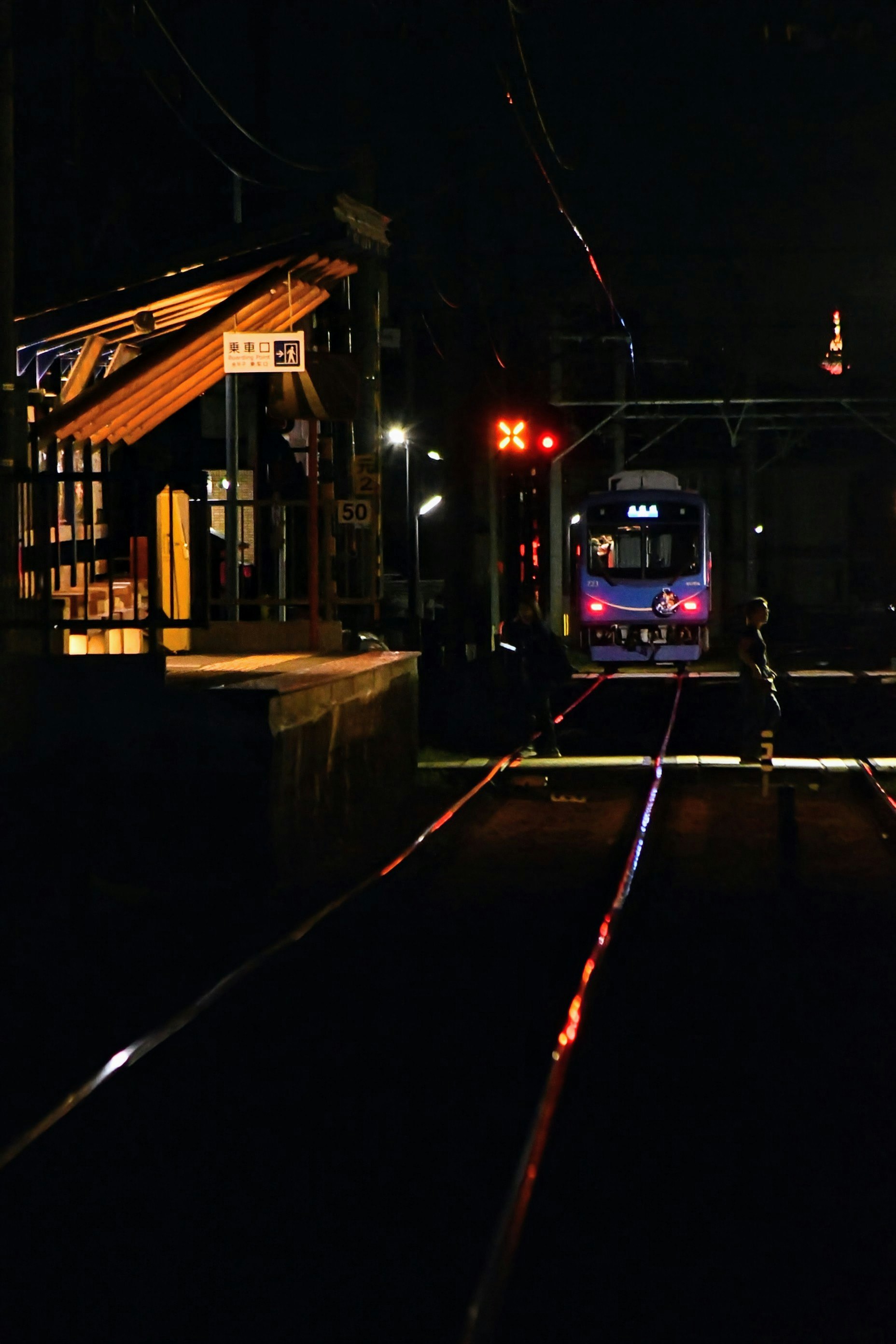 夜の叡山電鉄の線路と踏切のある街並み