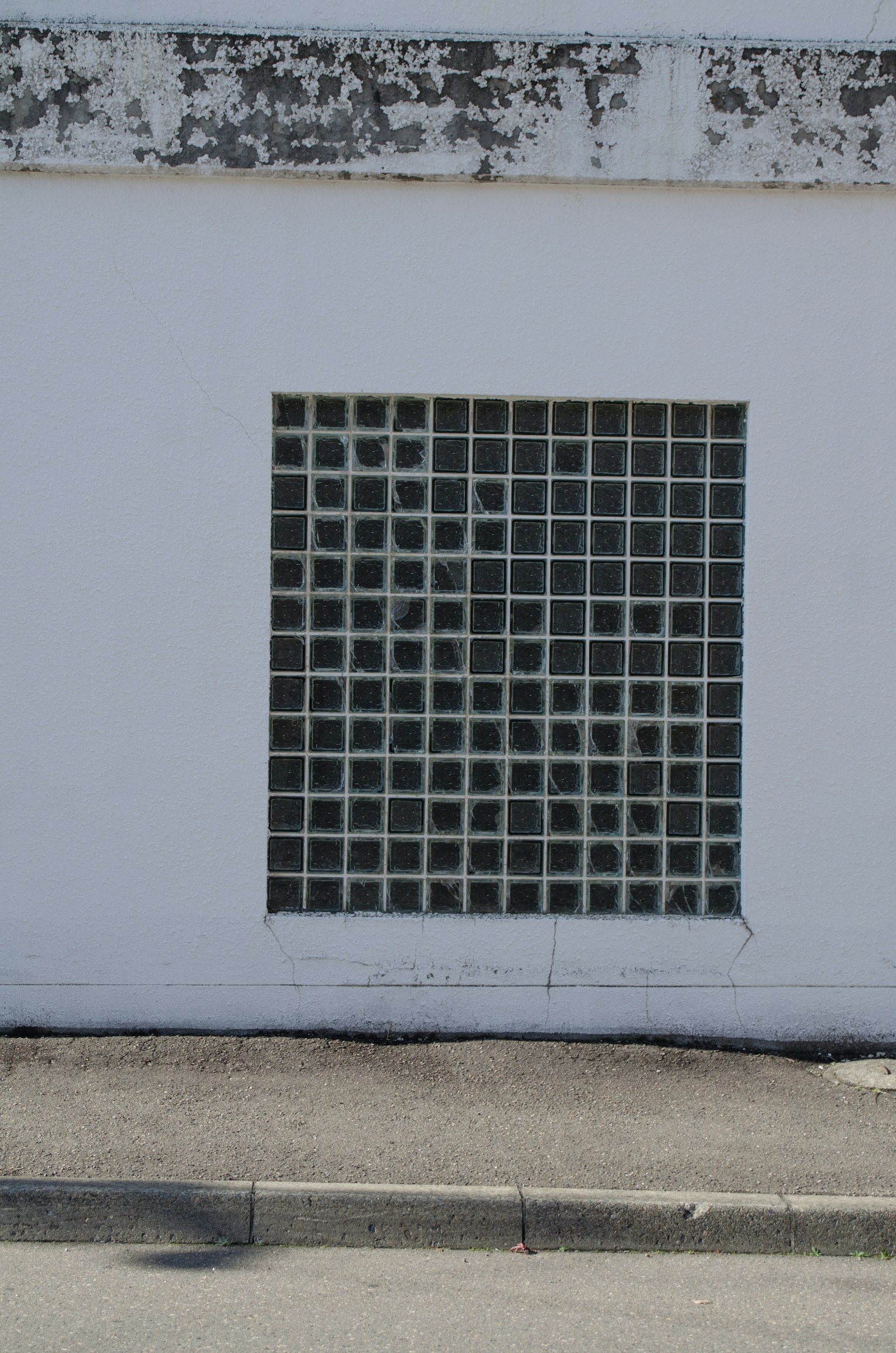 A white wall featuring a grid of glass blocks