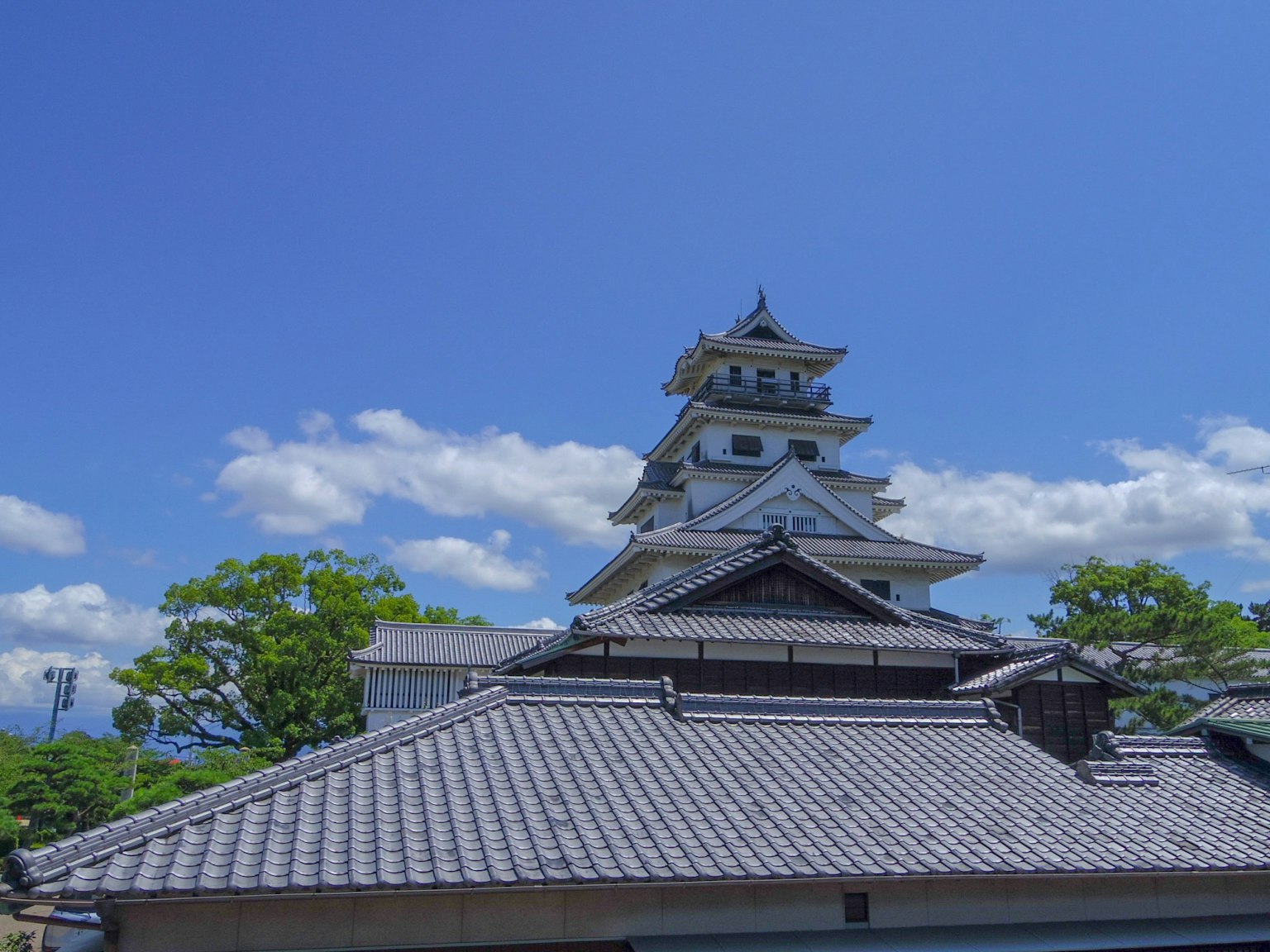 Un castillo blanco bajo un cielo azul con estructuras de techo tradicionales