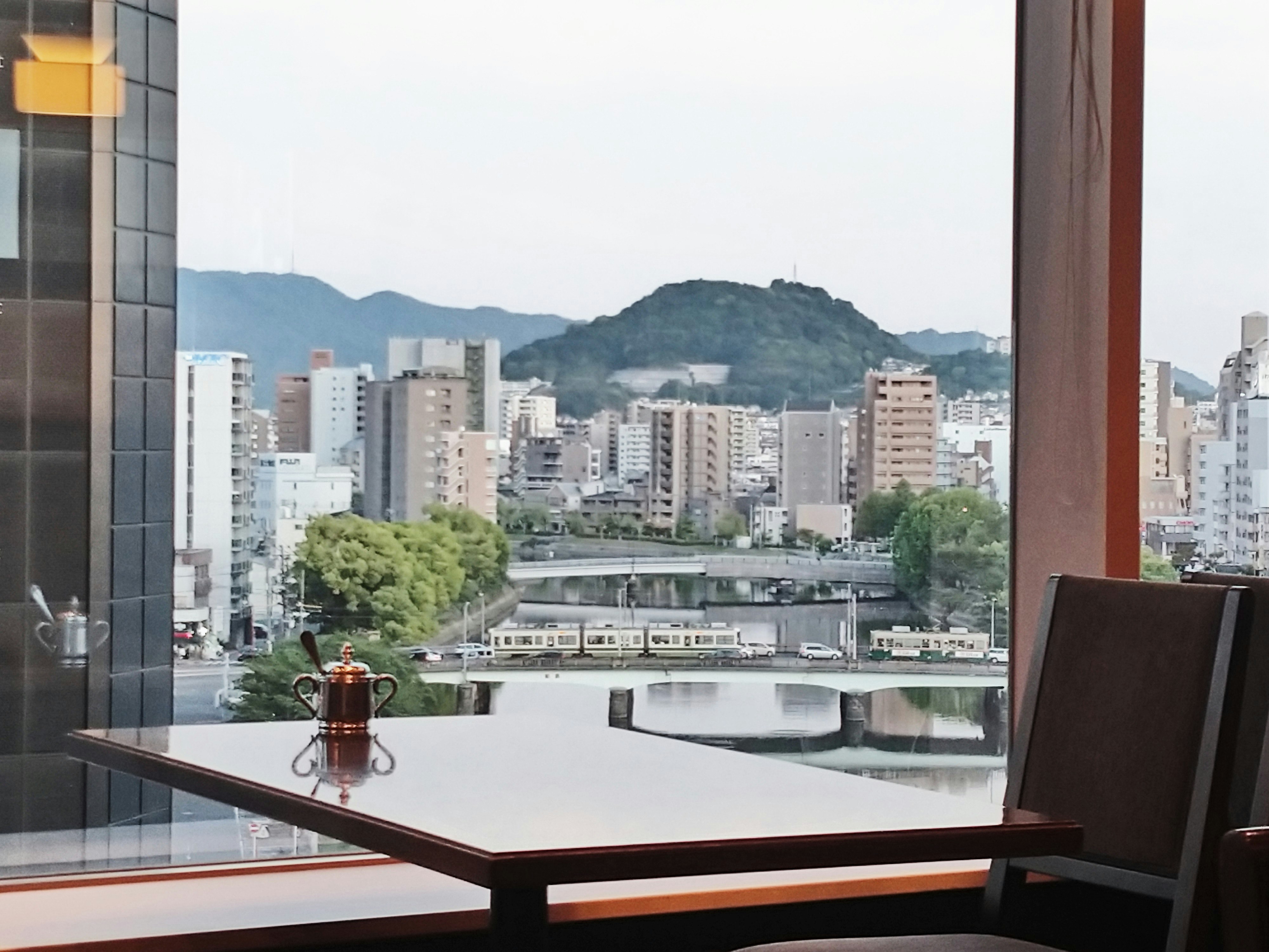 窓辺のカフェテーブルから見える街並みと山