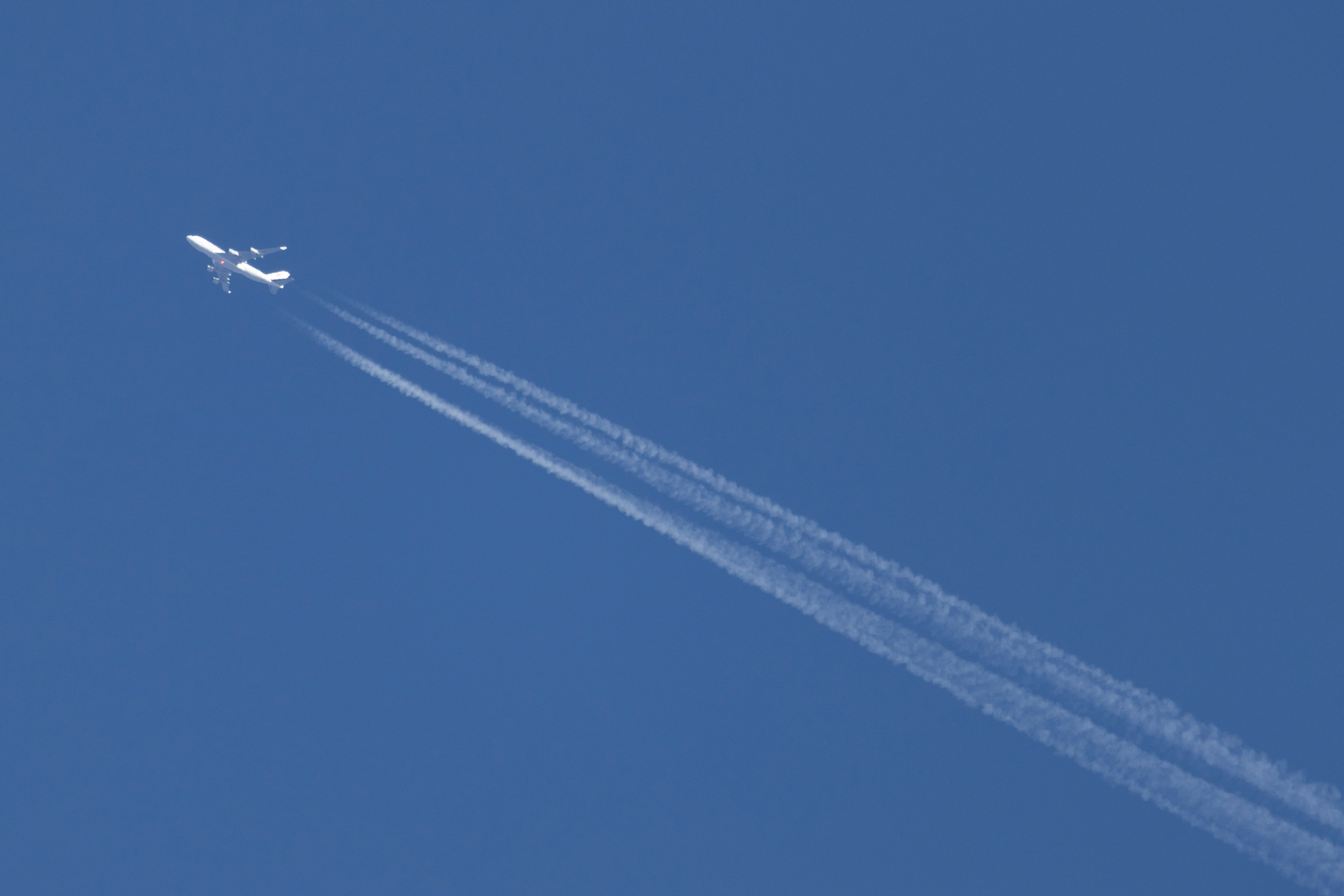 青空を飛ぶジェット機の飛行機雲