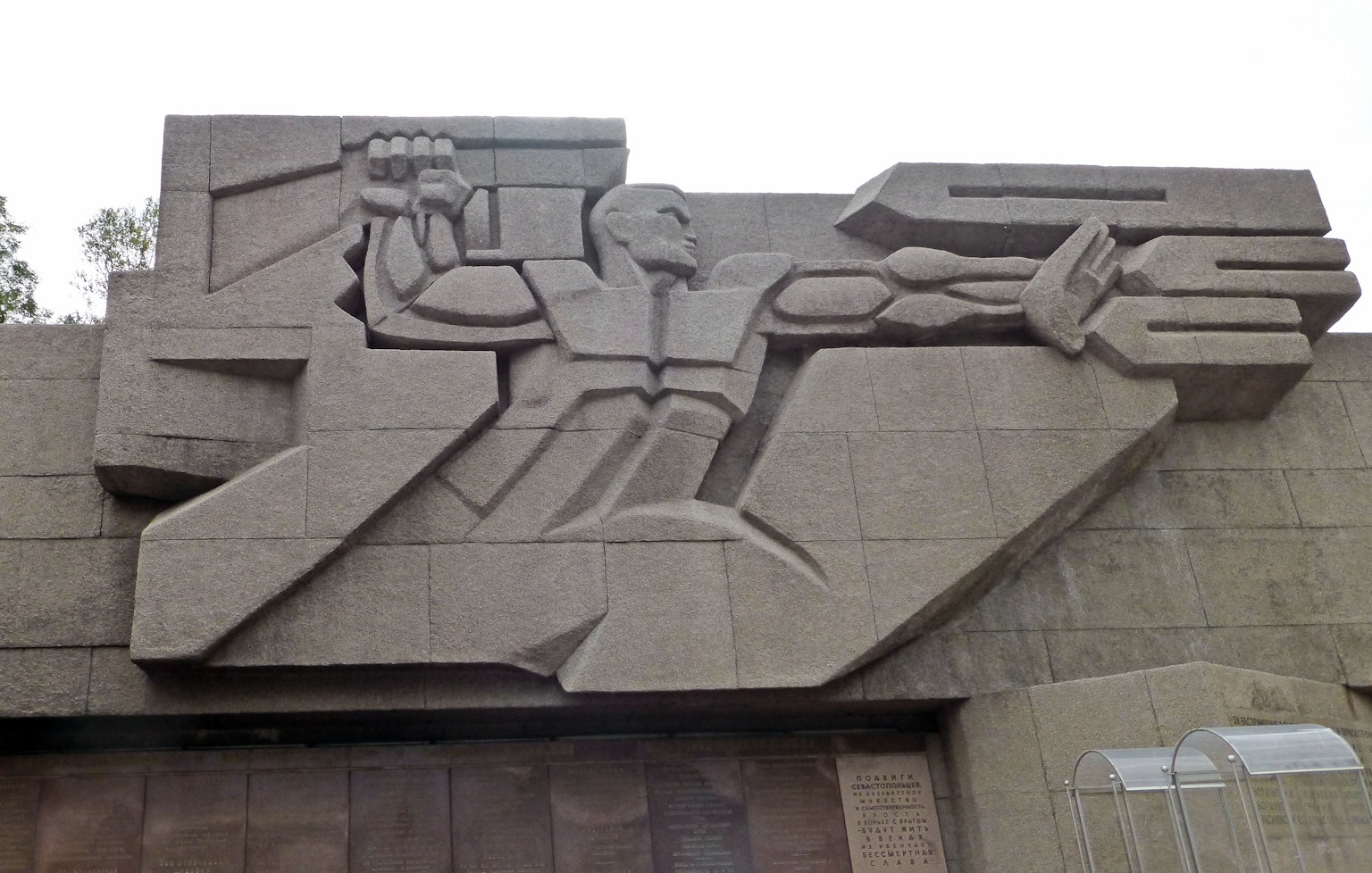 Scultura astratta con una figura che tiene un'arma