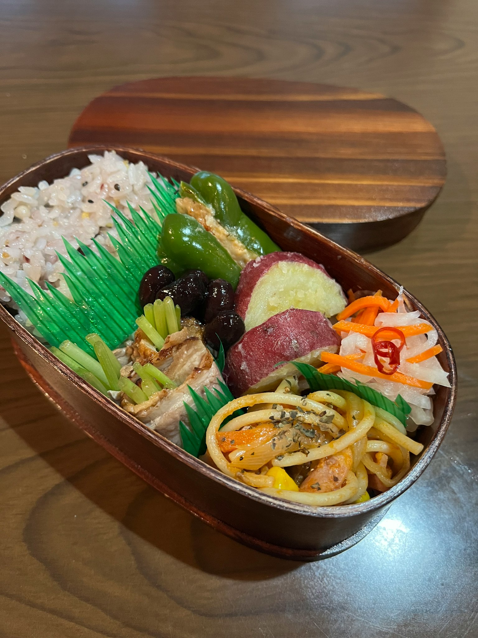 Bunte Gerichte in einer Holz-Bento-Box angeordnet