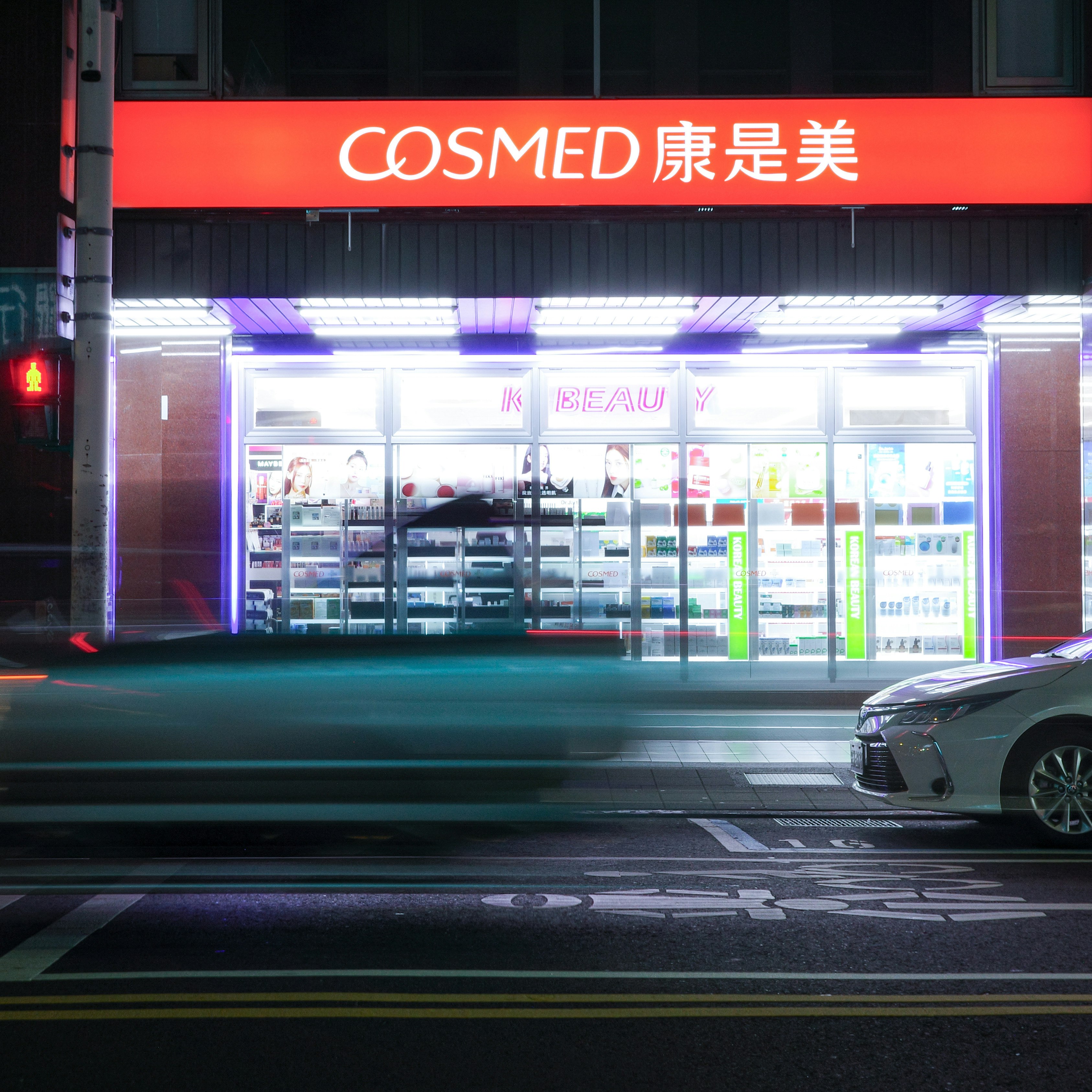 ネオン看板のある夜のビューティーショップ前の通り