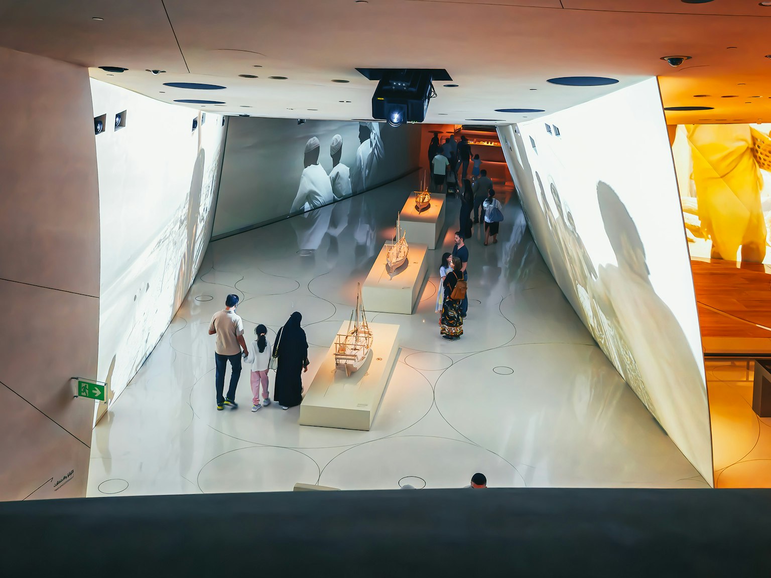 Keluarga yang mengamati pameran di museum modern dengan proyeksi video di dinding