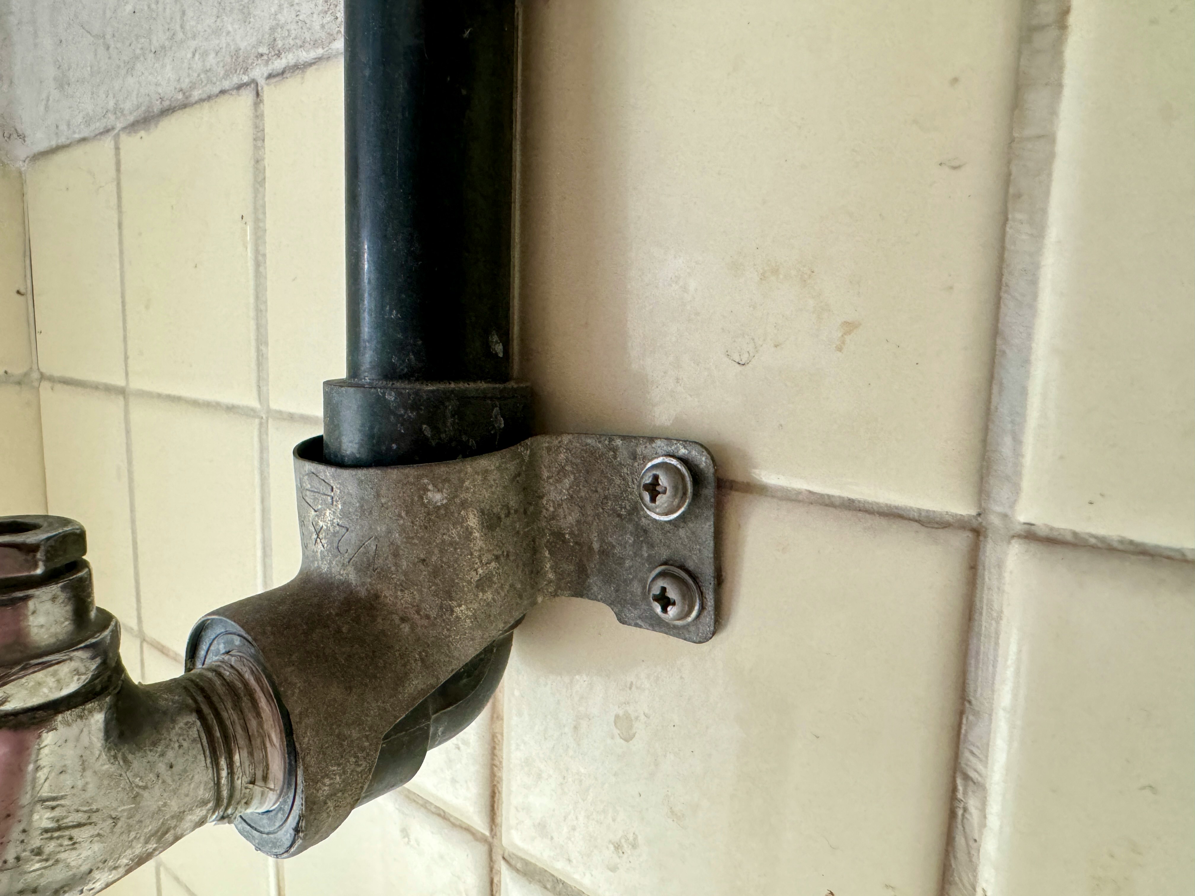rubinetto metallico montato su parete piastrellata
