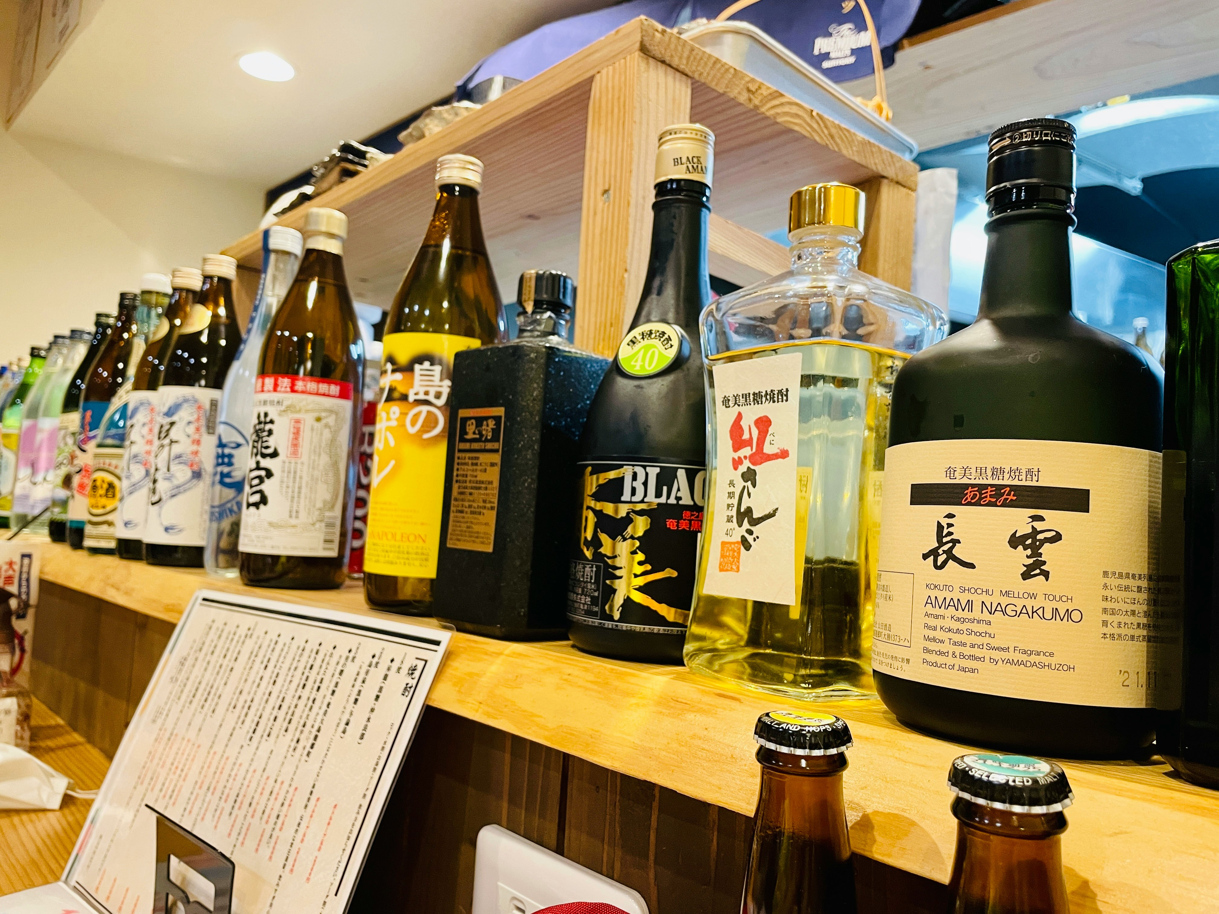 木質貨架上擺放的日本清酒與威士忌酒瓶