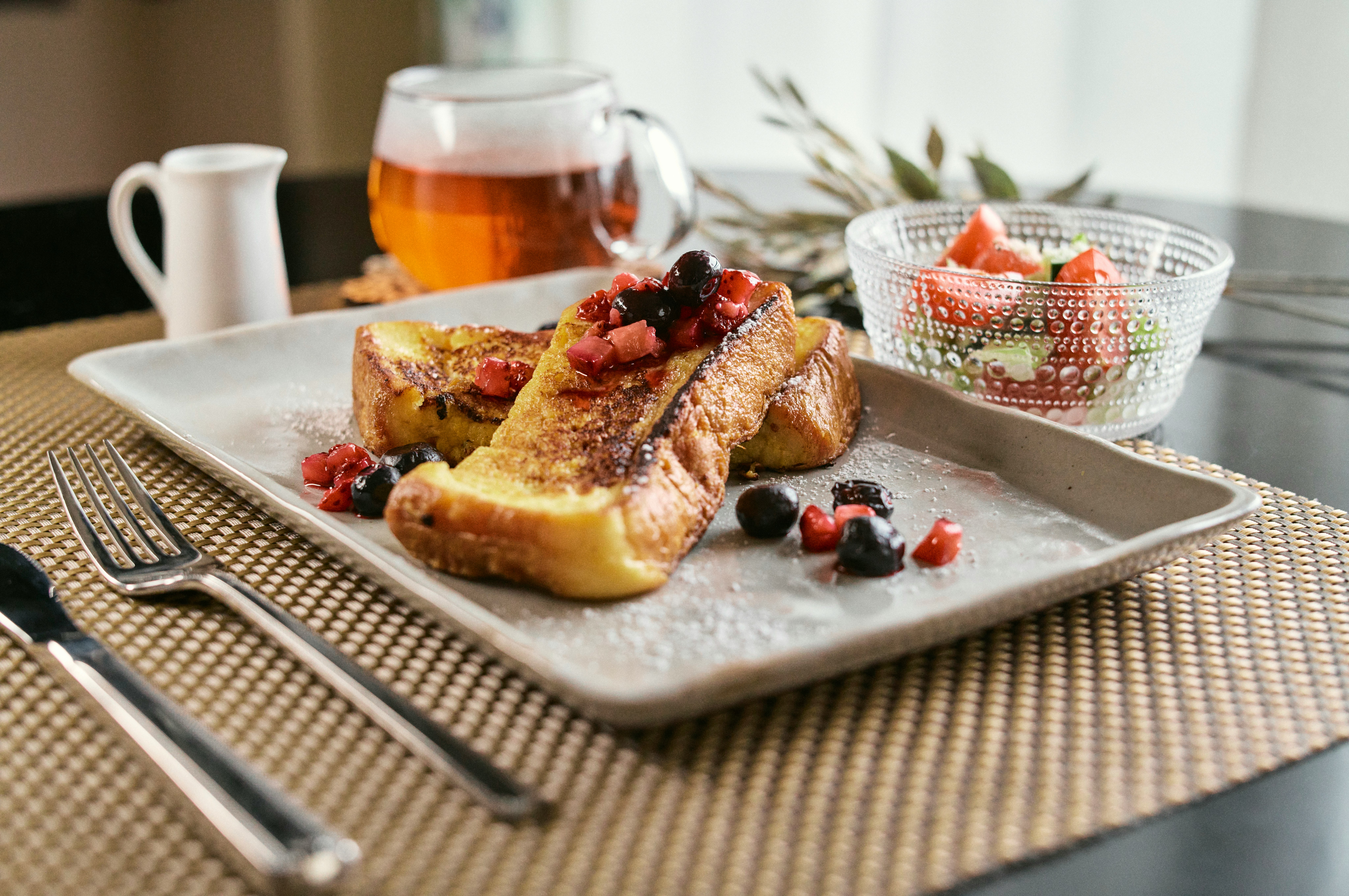 トーストとベリーの朝食プレートのあるテーブル
