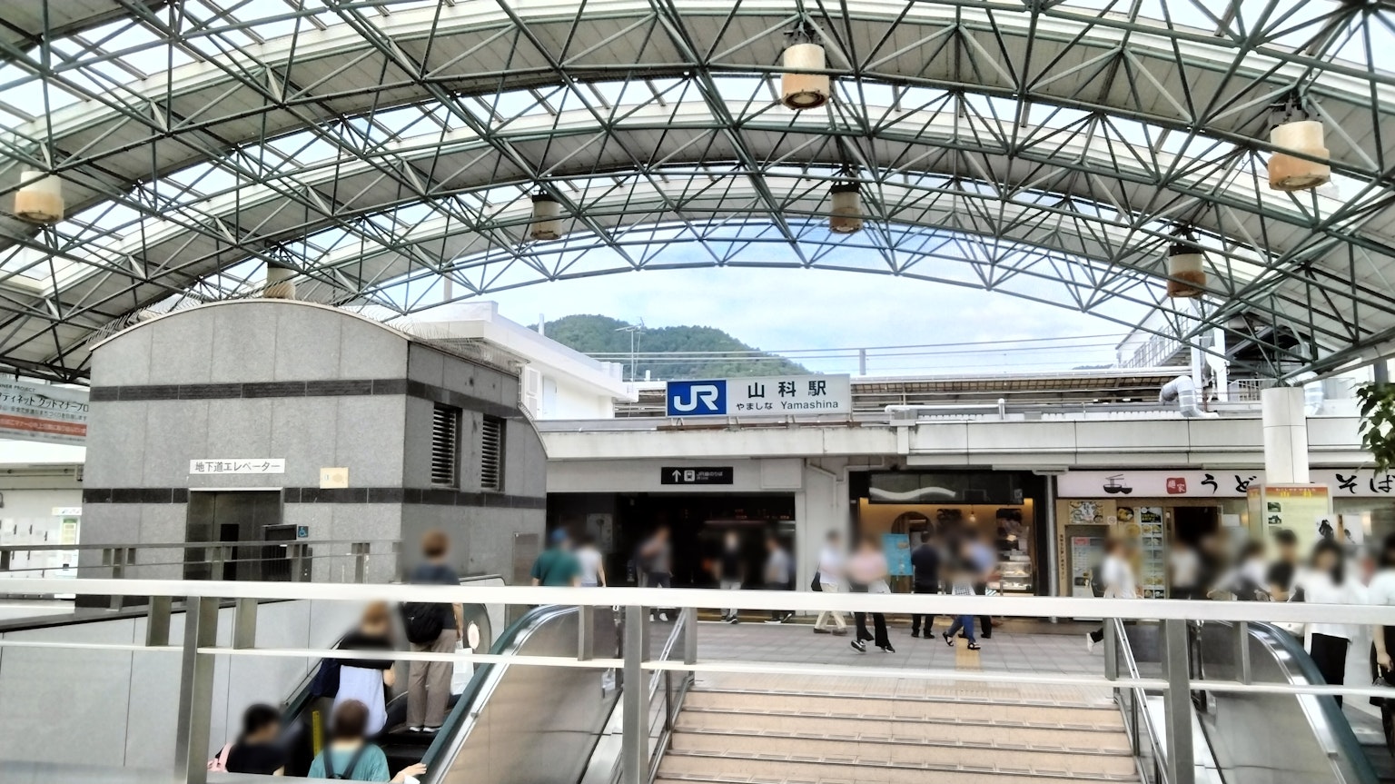 Escena concurrida que muestra la entrada de una estación de tren con una estructura de techo distintiva