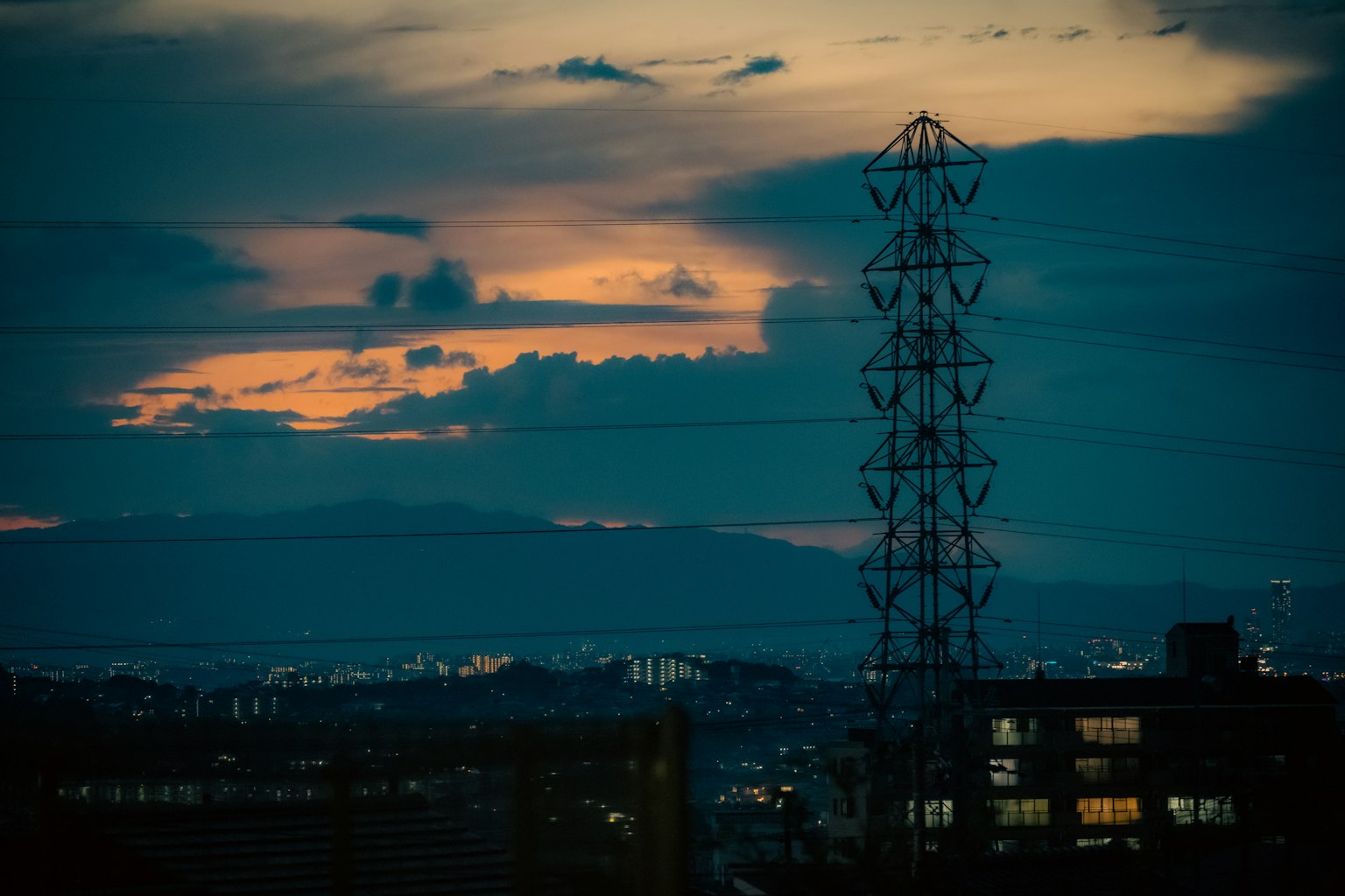 Paesaggio urbano con cielo al tramonto e torre di trasmissione