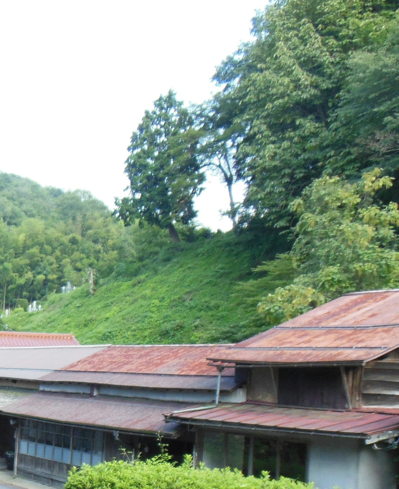 Pemandangan dengan bangunan tua dan bukit hijau di latar belakang