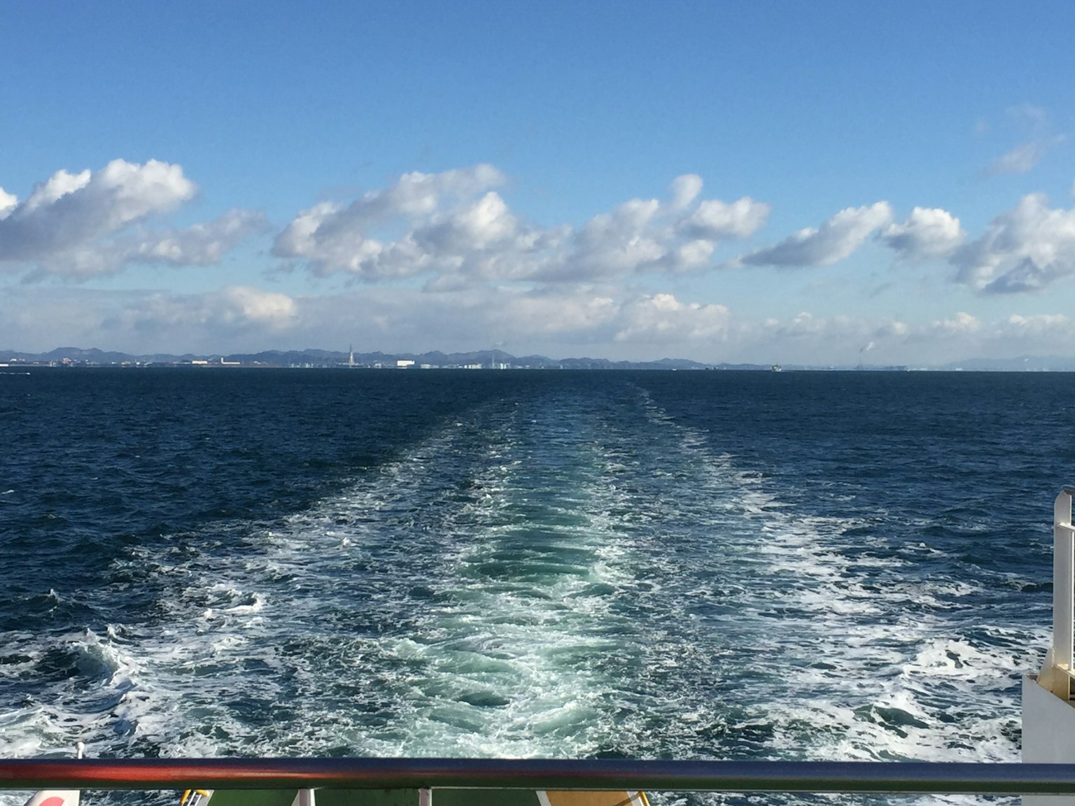 Vista escénica del océano azul y nubes blancas con la estela del ferry detrás