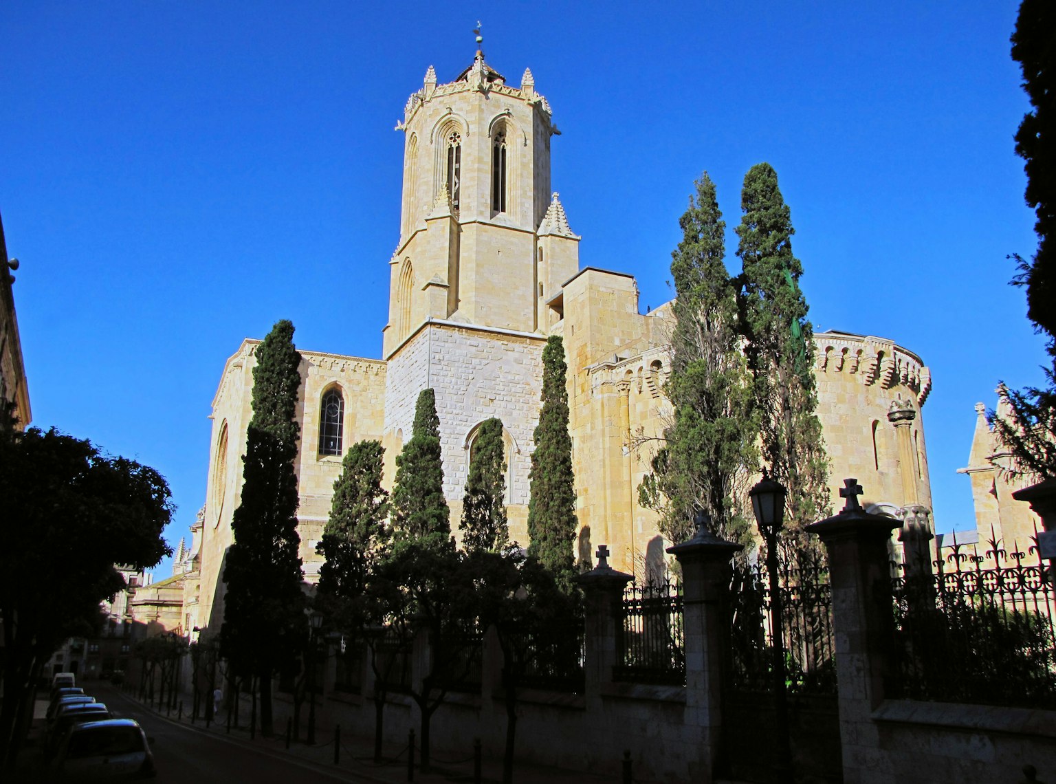 Esterno di una chiesa storica sotto un cielo azzurro luminoso con alberi verdi