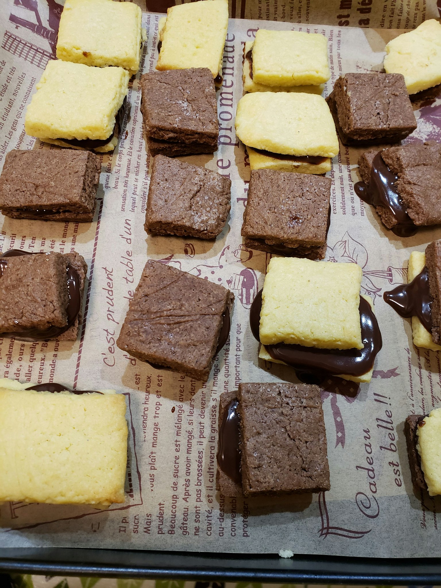 Un plateau de biscuits à la vanille et au chocolat disposés sur du papier parchemin