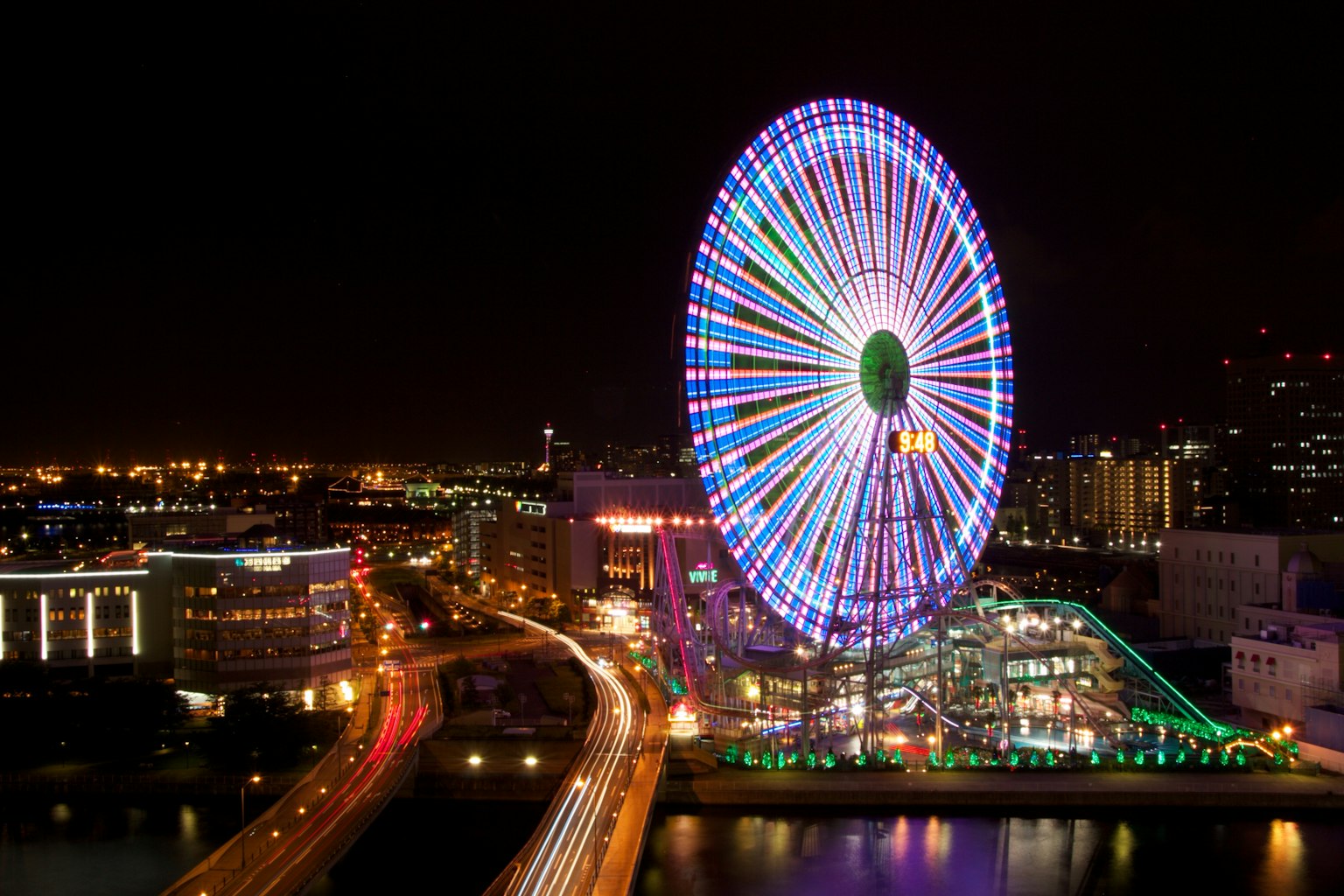 Grande roue colorée illuminée la nuit
