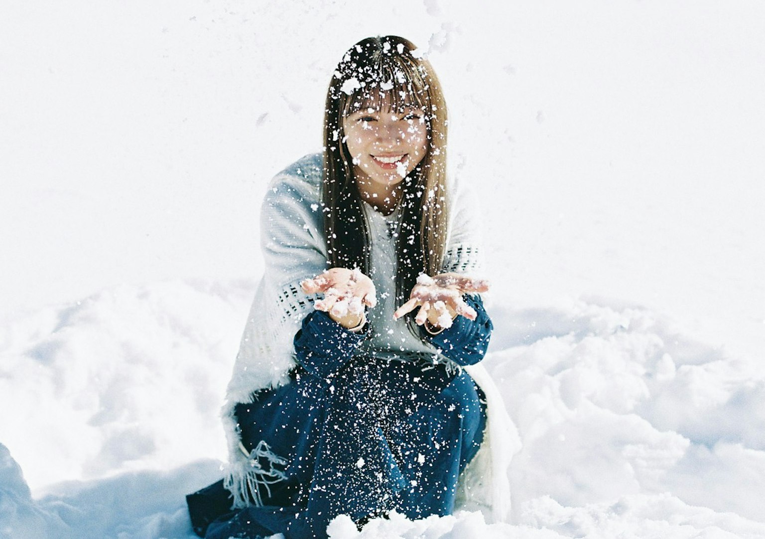 在冬季景觀中微笑的女性與雪玩耍的照片
