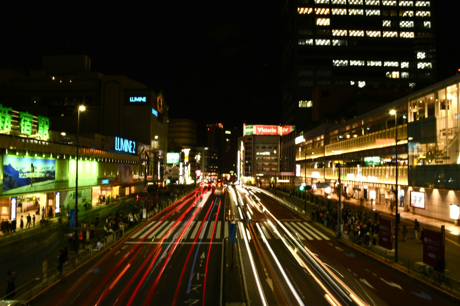 Vista notturna di un incrocio urbano con luci di auto in movimento