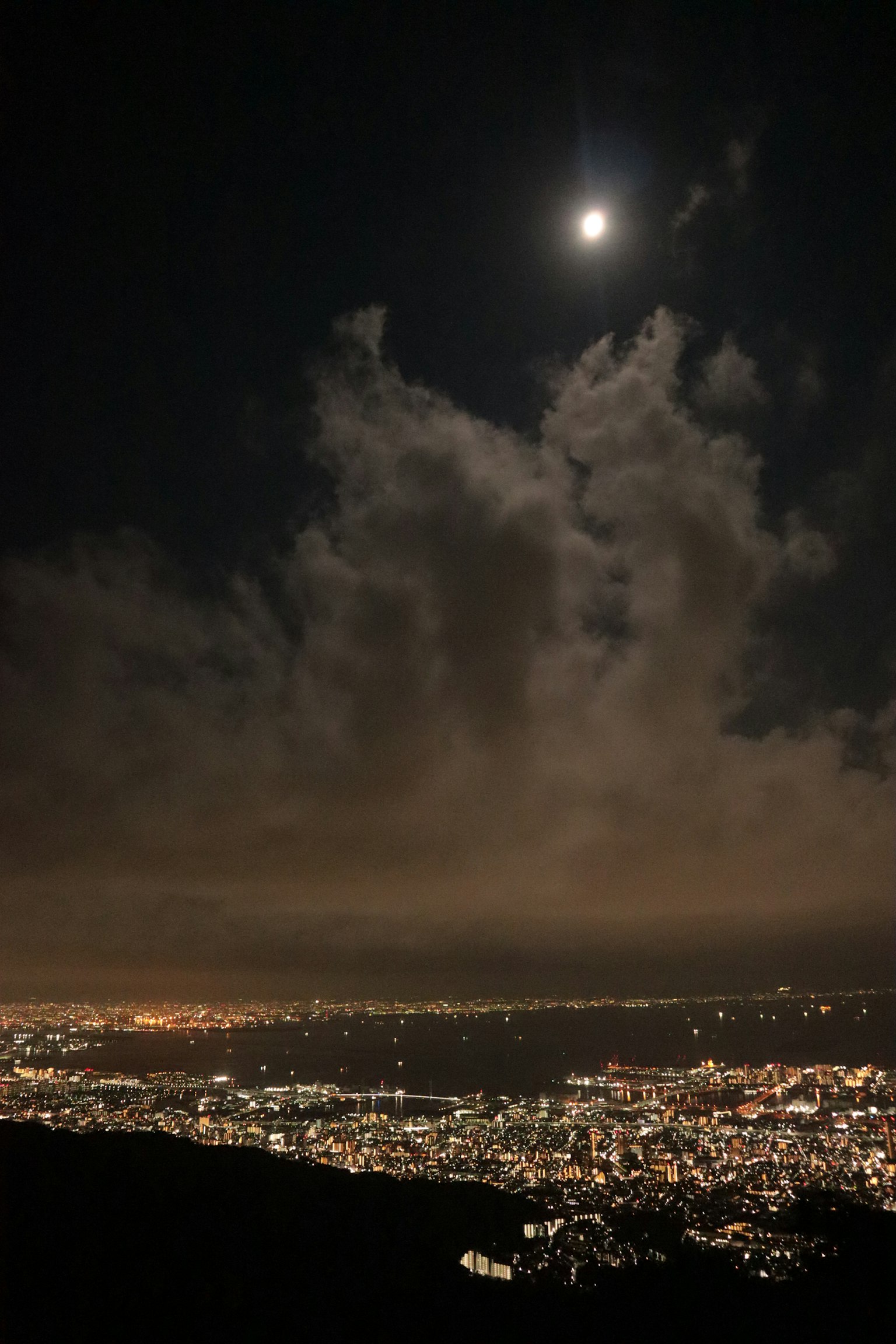 一个美丽的夜景，天空中有满月和云朵