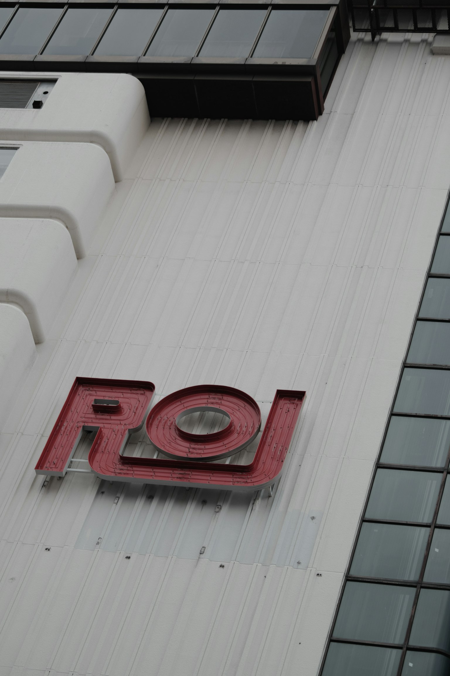 Façade de bâtiment avec un logo rouge portant les lettres ROJ