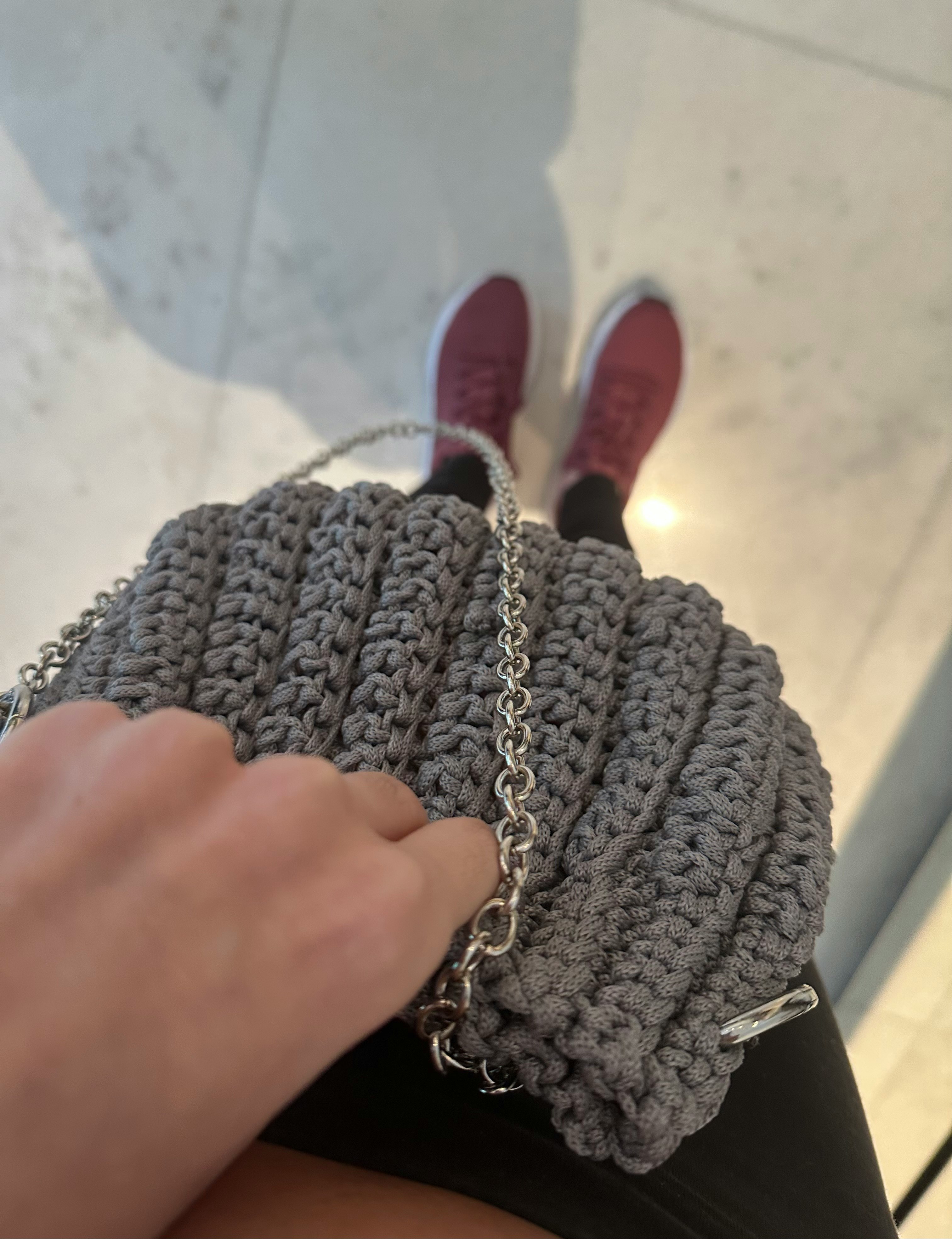 グレーのニットバッグと赤い靴のある室内の足元