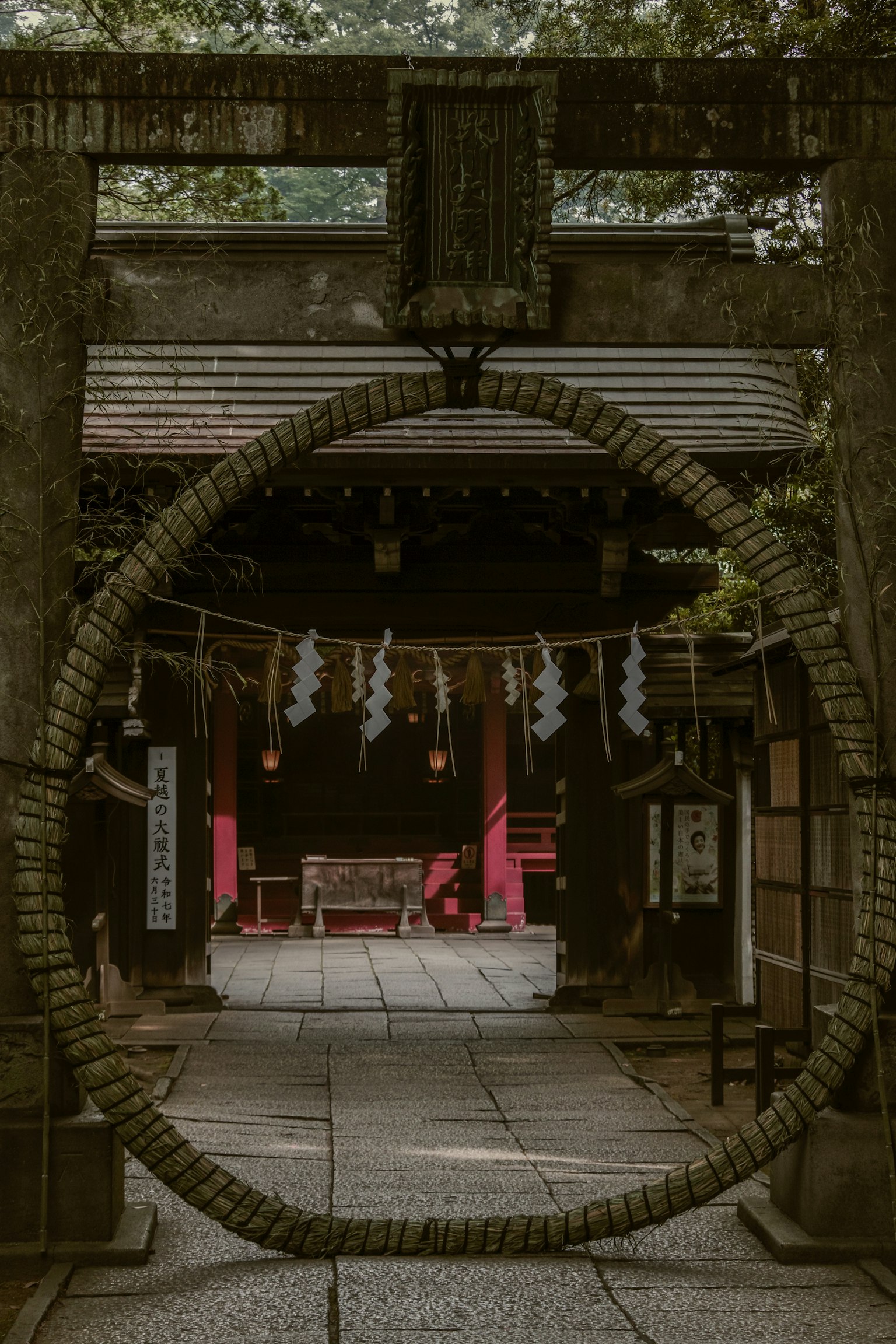 透过鸟居看到的圆形注连绳和红色装饰的神社