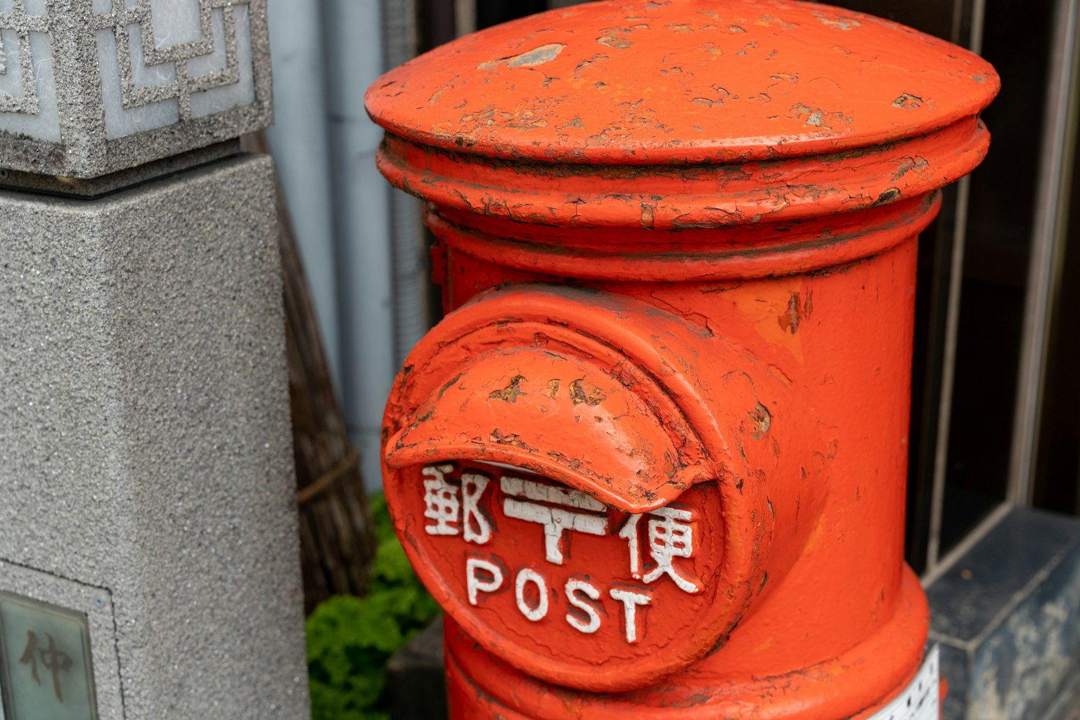 Boîte aux lettres orange avec texte en anglais et en japonais