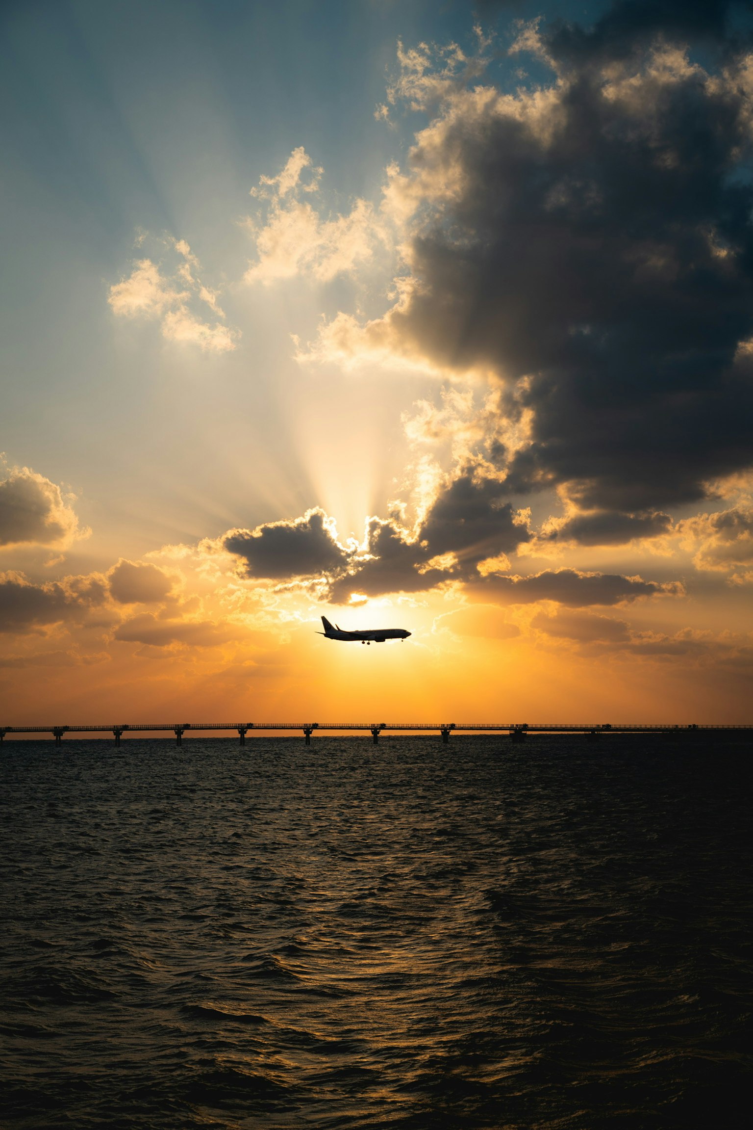 Silhouette of an airplane flying against a stunning sunset