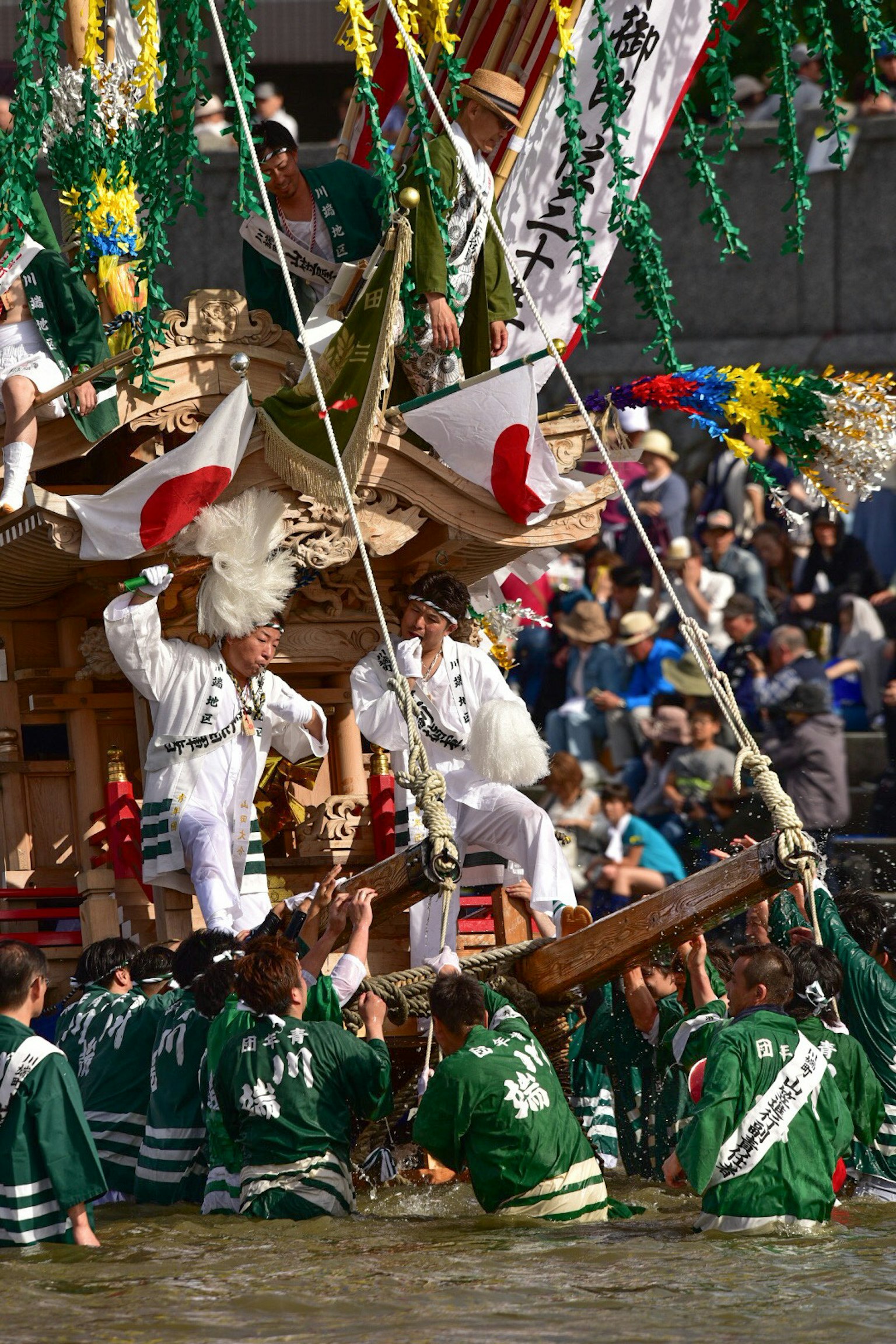 Người tham gia mang mikoshi trong lễ hội Nhật Bản với đám đông ở phía sau
