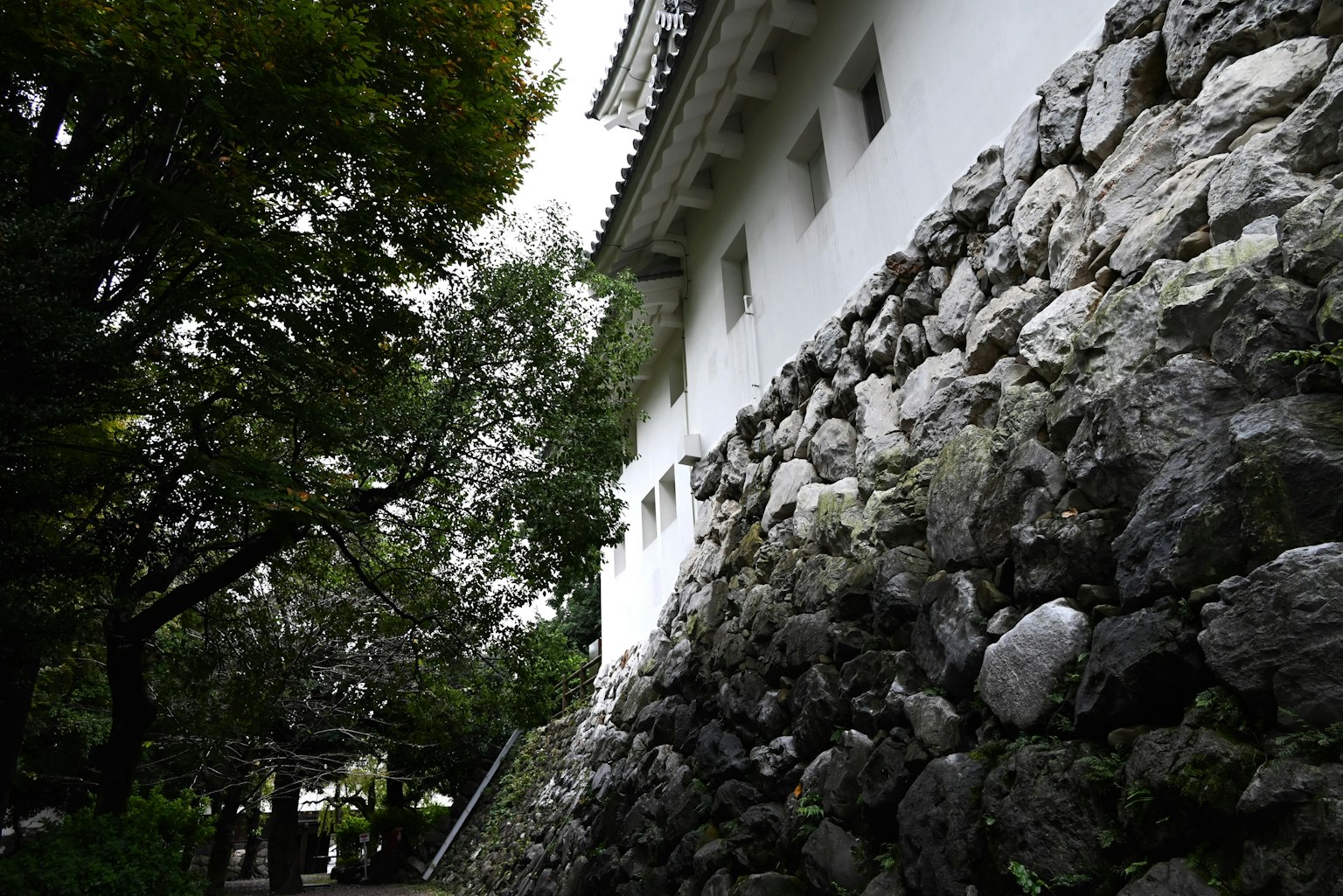 傳統日本建築的側面，白色牆壁和石頭基礎