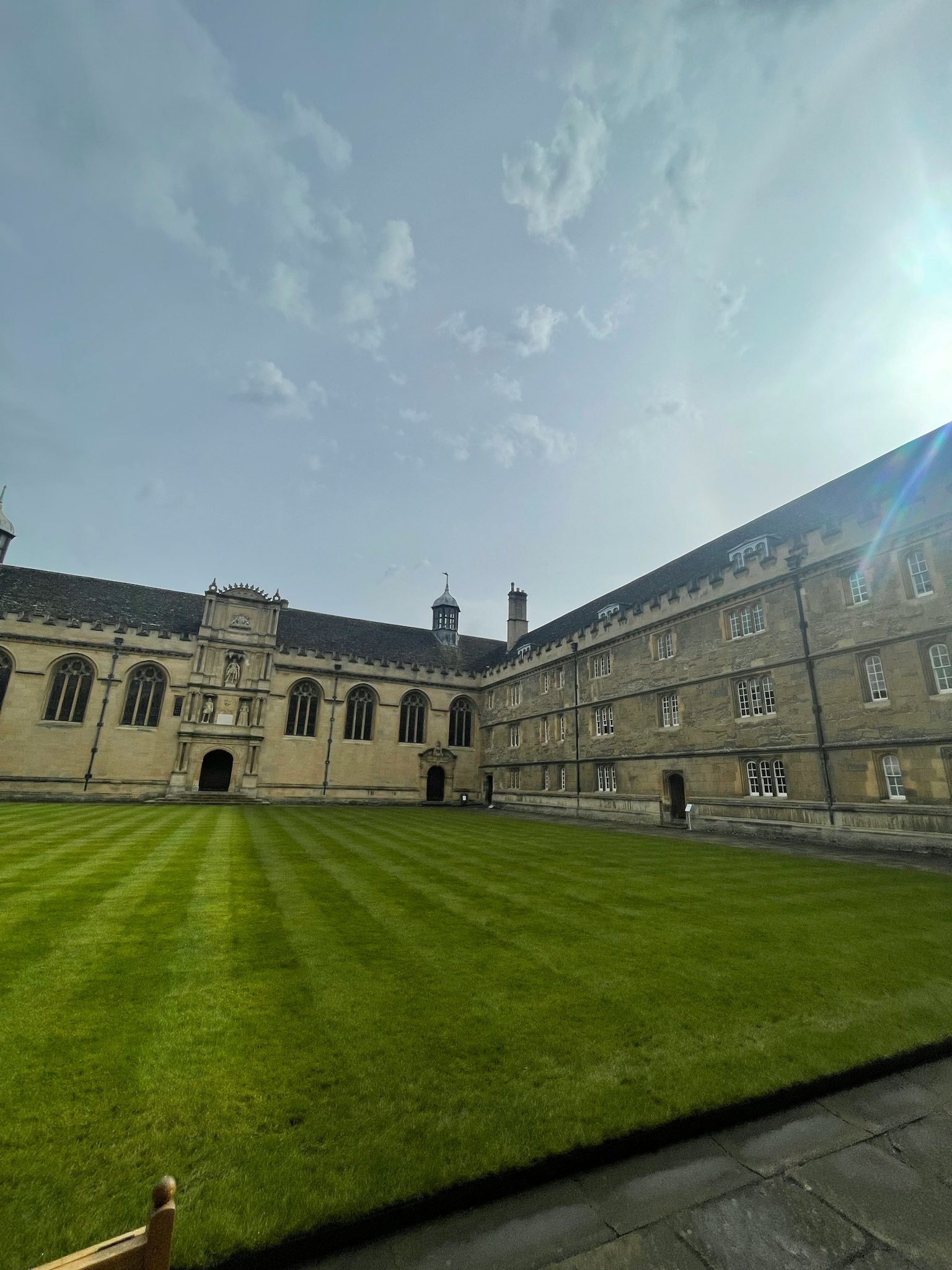 Hof der Universität mit grünem Gras und historischen Gebäuden