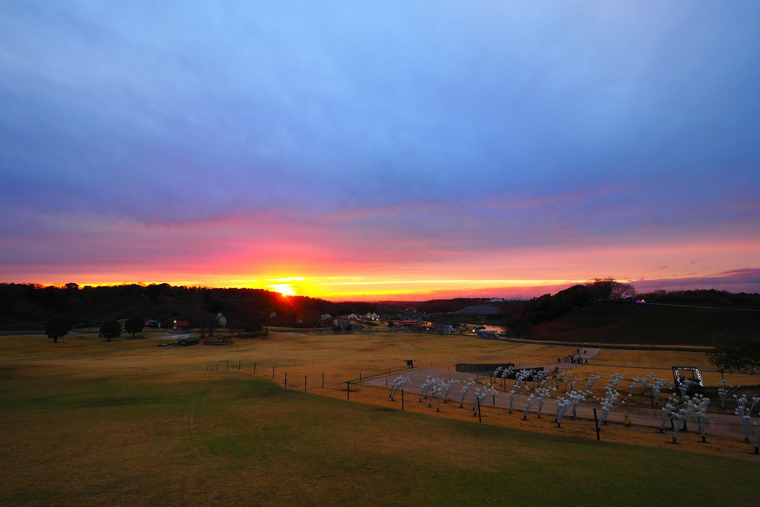 Malersicher Sonnenuntergang über einer grasbewachsenen Landschaft mit Wolken