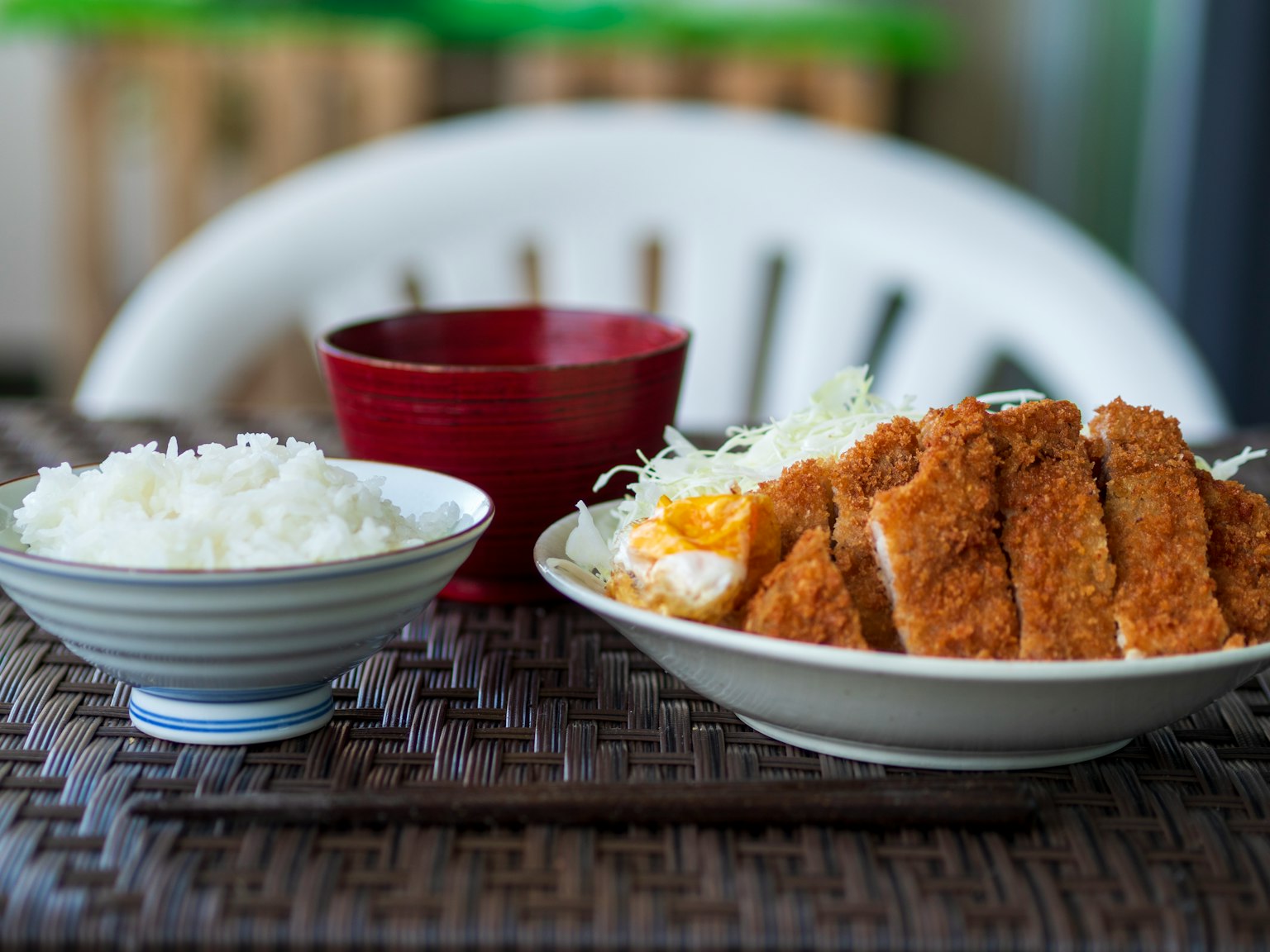 一盘酥脆的猪排配白米饭和切碎的卷心菜